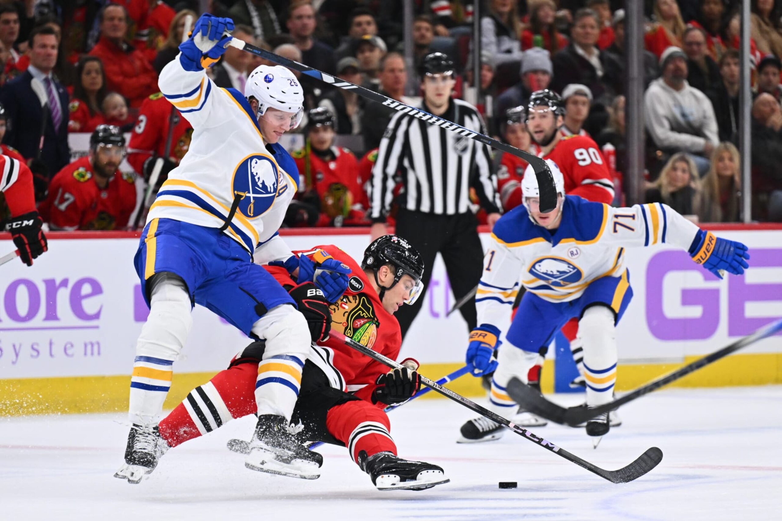CHICAGO, ILLINOIS - NOVEMBER 19:  Rasmus Dahlin #26 of the Buffalo Sabres checks Taylor Hall #71 of the Chicago Blackhawks off the puck in the first period on November 19, 2023 at United Center in Chicago, Illinois.  (Photo by Jamie Sabau/Getty Images)
