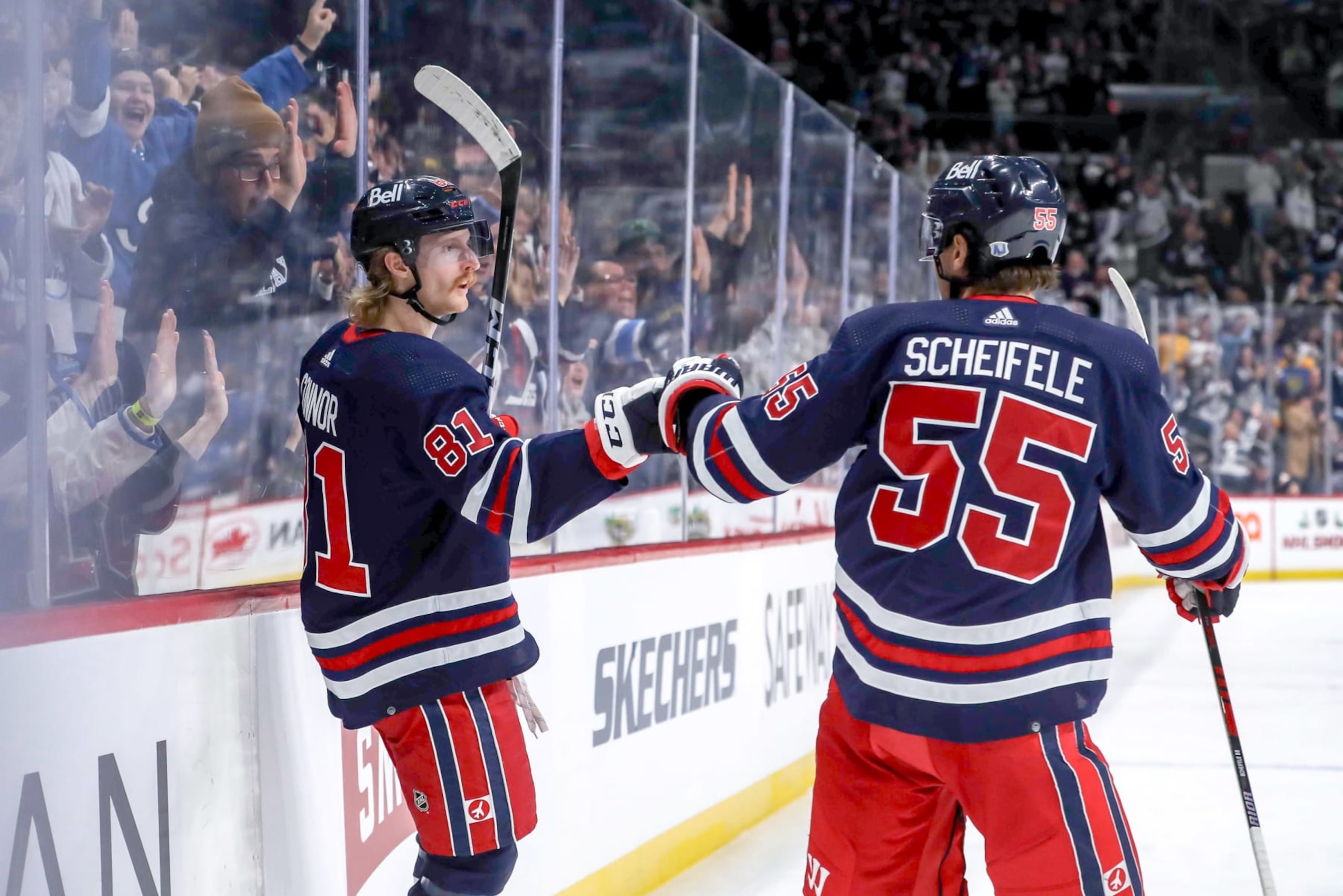 WINNIPEG, CANADA - NOVEMBER 18: Kyle Connor #81 and Mark Scheifele #55 of the Winnipeg Jets celebrate a second period goal against the Arizona Coyotes at the Canada Life Centre on November 18, 2023 in Winnipeg, Manitoba, Canada. (Photo by Darcy Finley/NHLI via Getty Images)