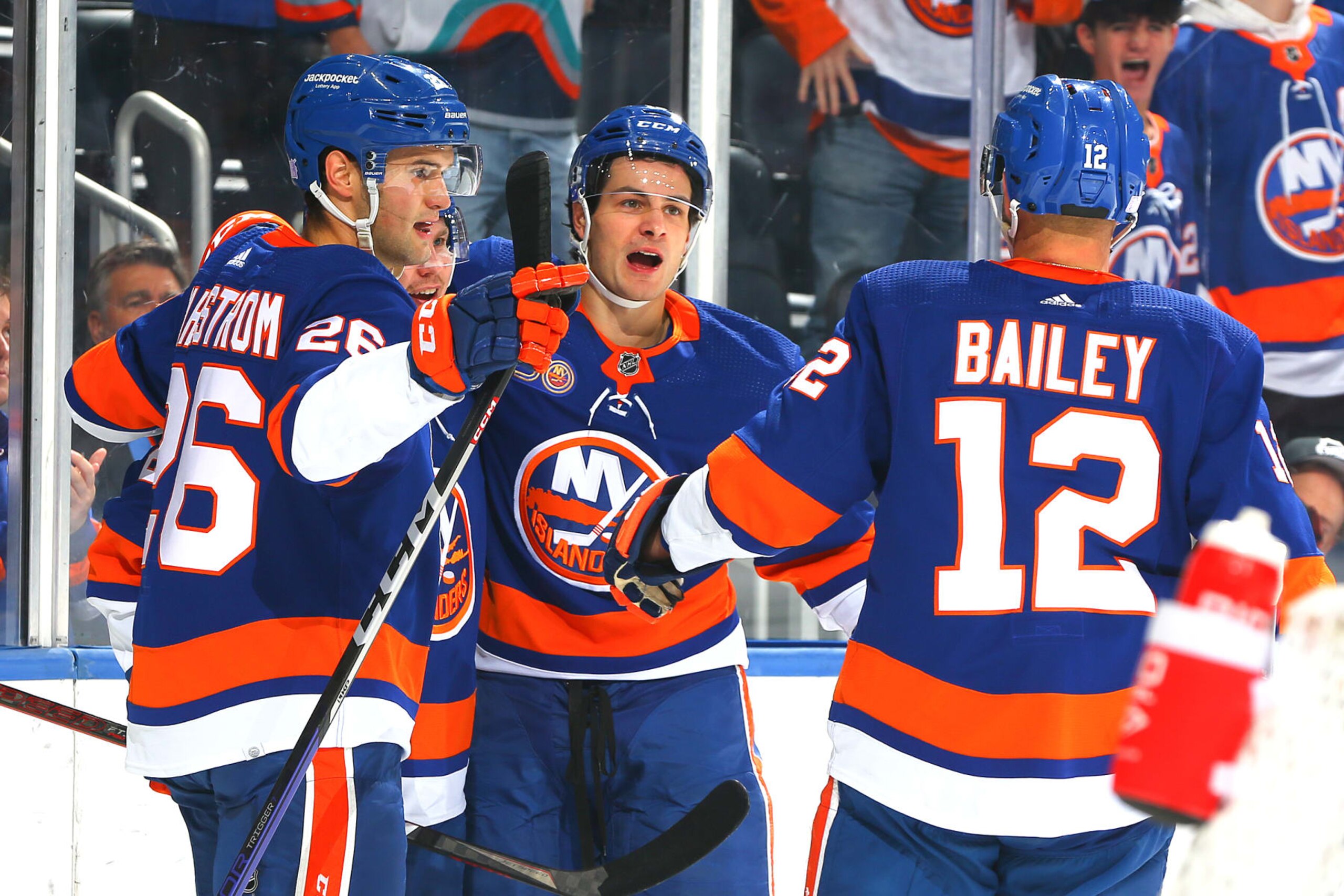 ELMONT, NEW YORK - NOVEMBER 07: Sebastian Aho #25 of the New York Islanders is congratulated by Josh Bailey #12 and Oliver Wahlstrom #26 after scoring a goal against the Calgary Flames during the first period at UBS Arena on November 07, 2022 in Elmont, New York. (Photo by Mike Stobe/NHLI via Getty Images)