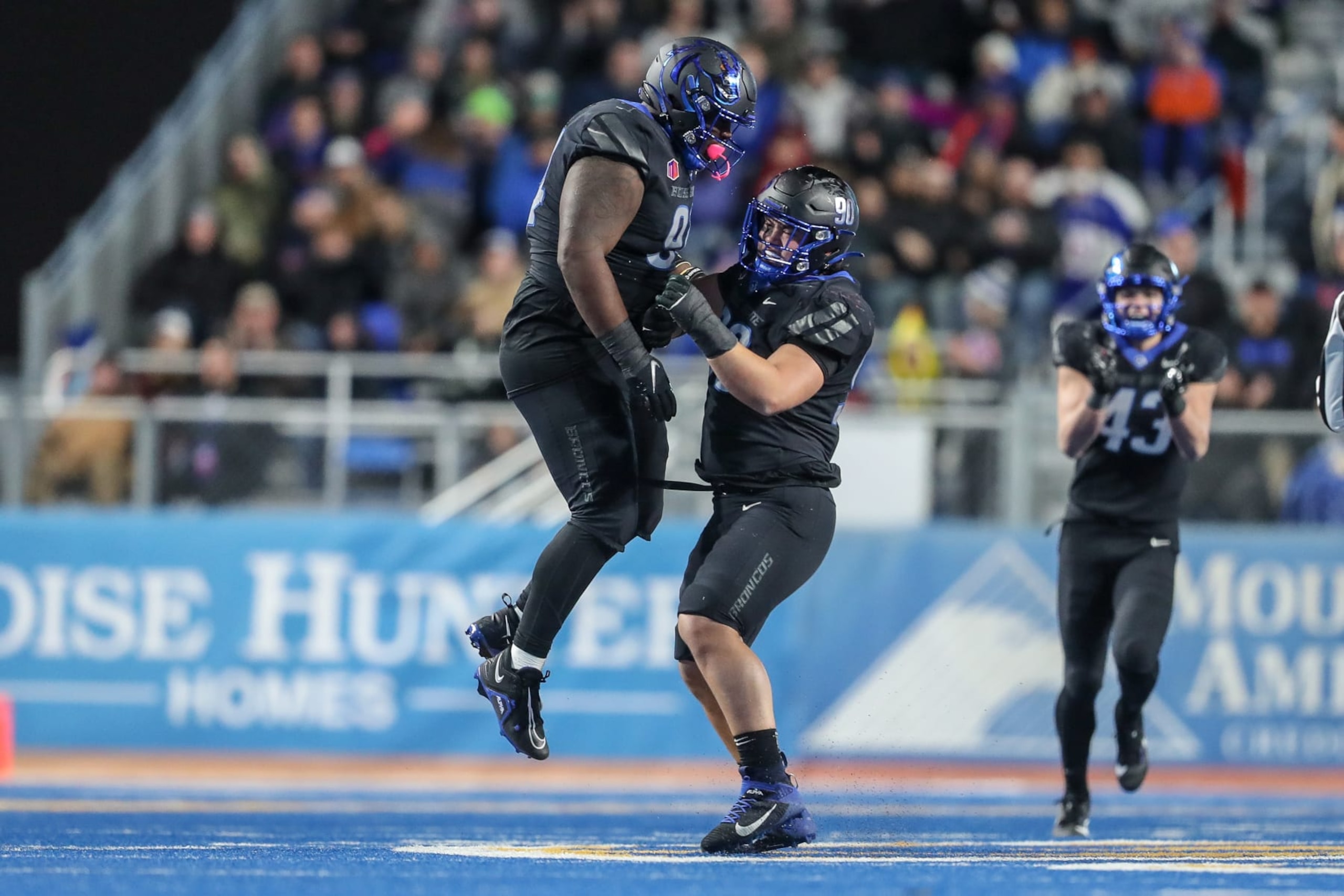 BOISE, ID - NOVEMBER 11: Nose tackle Sheldon Newton #94 and defensive tackle Braxton Fely #90 of the Boise State Broncos celebrate a defensive play during the second half against the New Mexico Lobos at Albertsons Stadium on November 11, 2023 in Boise, Idaho. Boise State won the game 42-14. (Photo by Loren Orr/Getty Images)