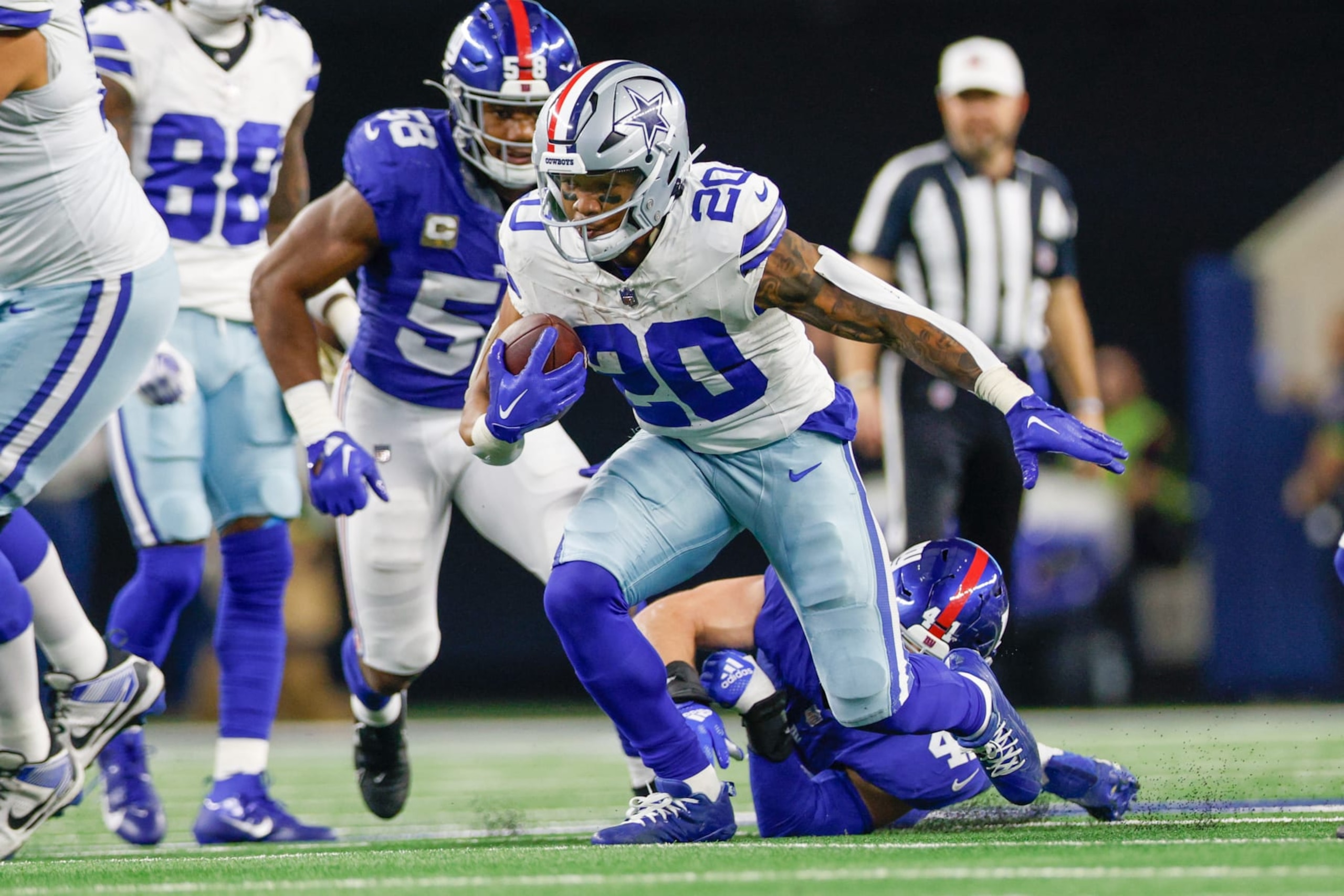 ARLINGTON, TX - NOVEMBER 12: Dallas Cowboys running back Tony Pollard (20) breaks through a tackle attempt by New York Giants linebacker Micah McFadden (41) during the game between the Dallas Cowboys and New York Giants on November 12, 2023 at AT&T Stadium in Arlington, TX. (Photo by Andrew Dieb/Icon Sportswire via Getty Images)