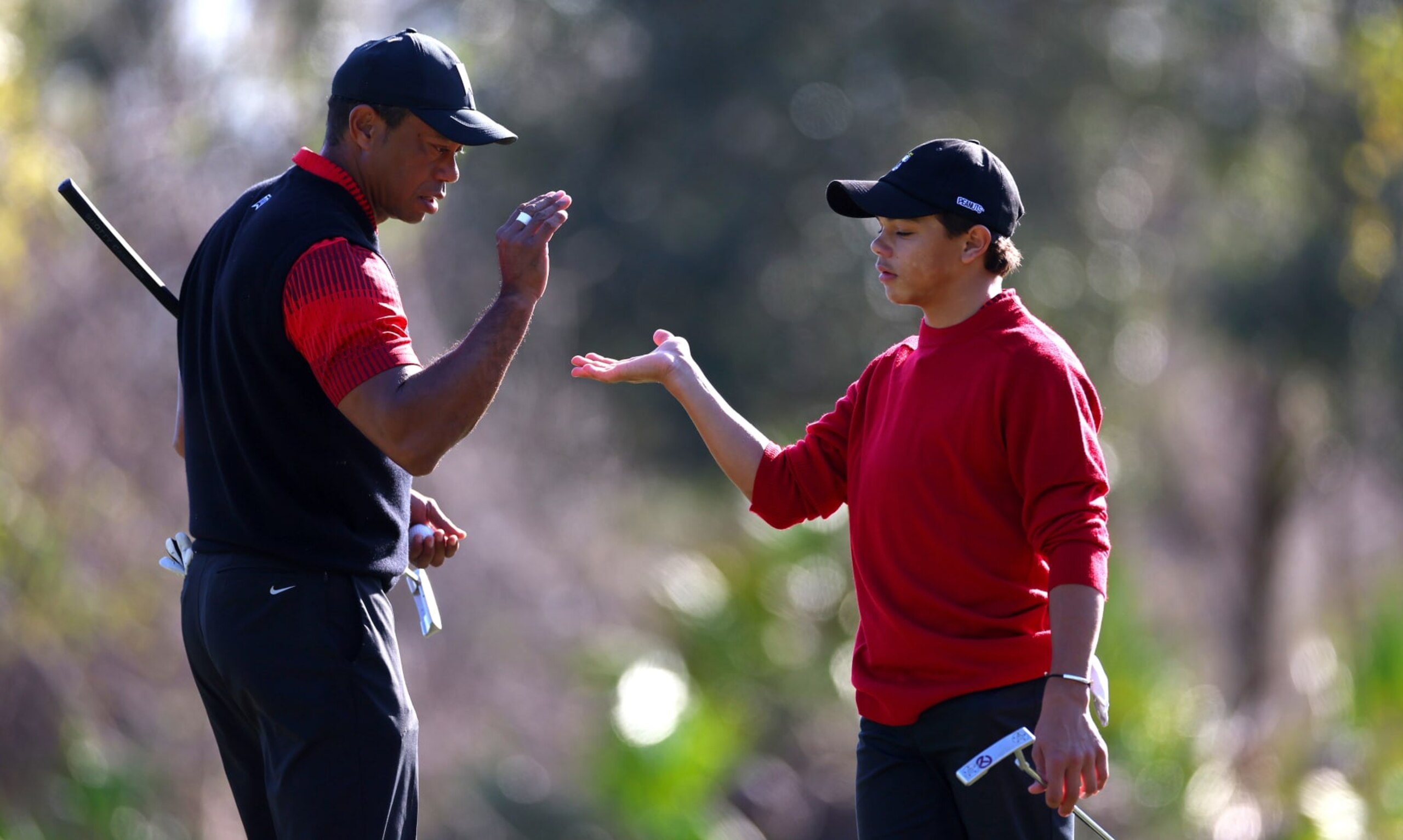 ORLANDO, FLORIDA - DECEMBER 18: Tiger Woods and Charlie Woods high five on the 1th hole during the final round of the PNC Championship at Ritz-Carlton Golf Club on December 18, 2022 in Orlando, Florida. (Photo by Mike Ehrmann/Getty Images)
