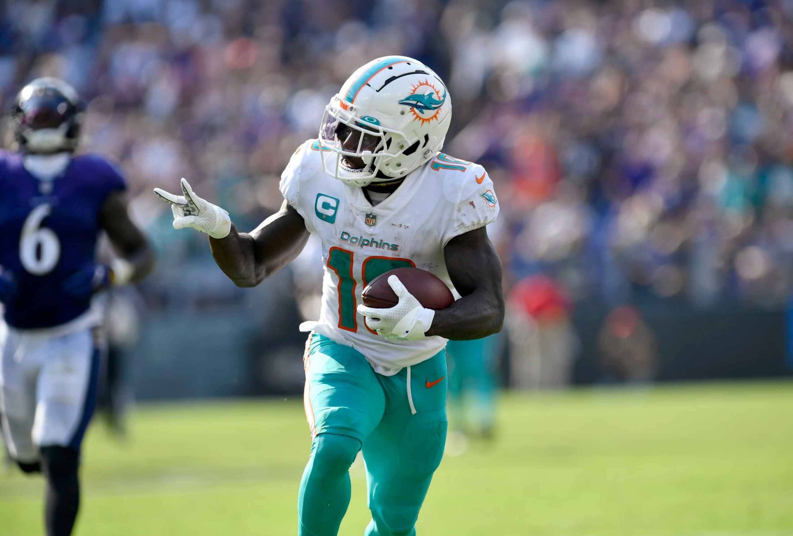 BALTIMORE, MD - SEPTEMBER 18: Miami Dolphins wide receiver Tyreek Hill (10) throws up a peace sign of two fingers after making a catch before running the rest of the way into the end zone for a touchdown during the Miami Dolphins versus Baltimore Ravens NFL game at M&T Bank Stadium on September 18, 2022 in Baltimore, MD (Photo by Randy Litzinger/Icon Sportswire via Getty Images)