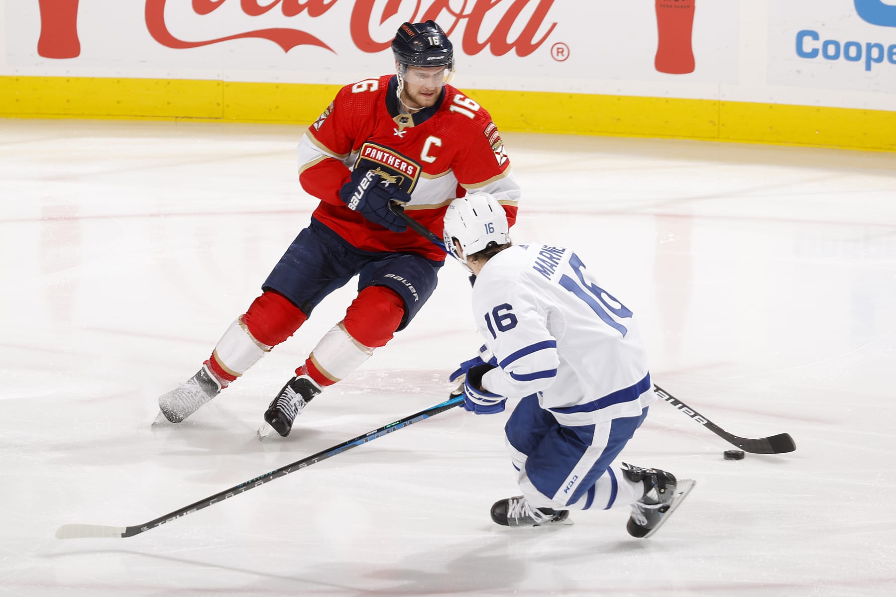 Florida Panthers captain Aleksander Barkov (left) skates past Toronto Maple Leafs winger Mitch Marner. 