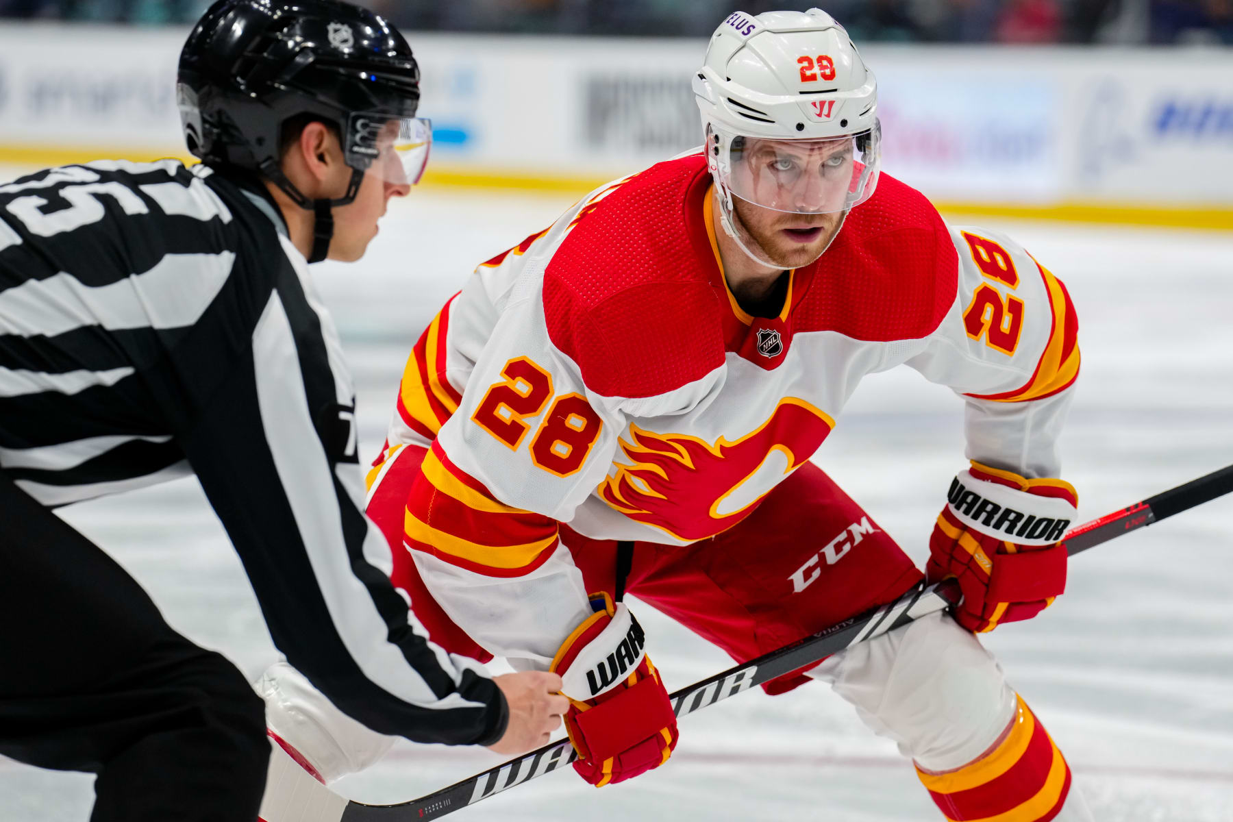 SEATTLE, WASHINGTON - NOVEMBER 20: Elias Lindholm #28 of the Calgary Flames faces off during the second period of a game against the Seattle Kraken at Climate Pledge Arena on November 20, 2023 in Seattle, Washington. (Photo by Christopher Mast/NHLI via Getty Images)
