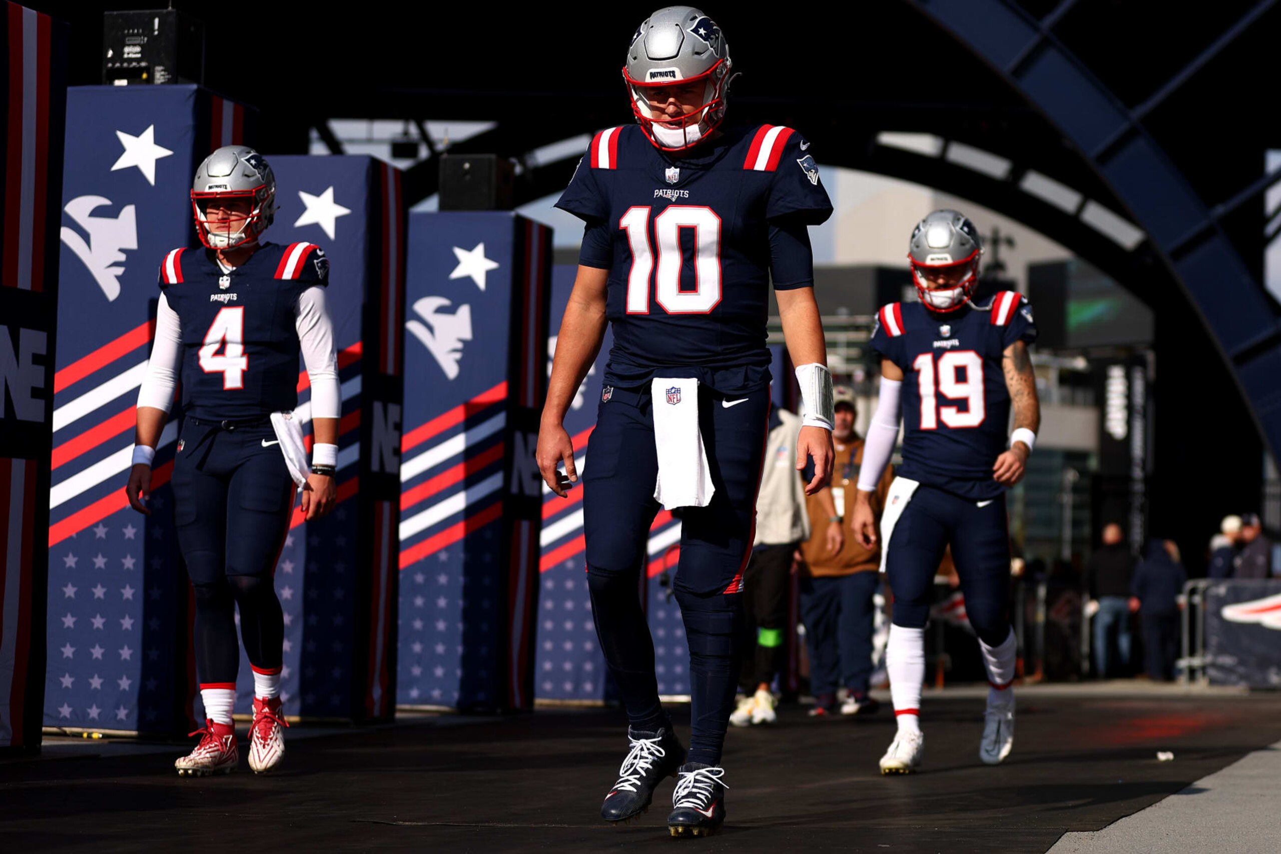 FOXBOROUGH, MASSACHUSETTS - NOVEMBER 05: Mac Jones #10 of the New England Patriots, Bailey Zappe #4, and Will Grier #19 walk onto the field before the game against the Washington Commanders at Gillette Stadium on November 05, 2023 in Foxborough, Massachusetts. (Photo by Maddie Meyer/Getty Images)