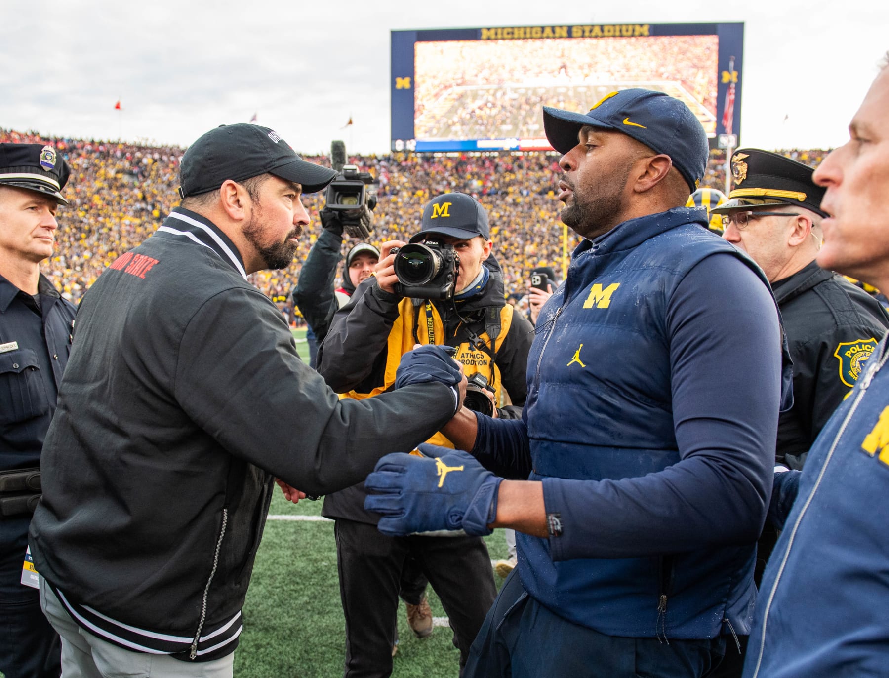ANN ARBOR, MICHIGAN - NOVEMBER 25: Head Football Coaches Ryan Day (L) of the Ohio State Buckeyes and Sherrone Moore (R) of the Michigan Wolverines shake hands after a college football game at Michigan Stadium on November 25, 2023 in Ann Arbor, Michigan. The Michigan Wolverines won the game 30-24 to win the Big Ten East. (Photo by Aaron J. Thornton/Getty Images)