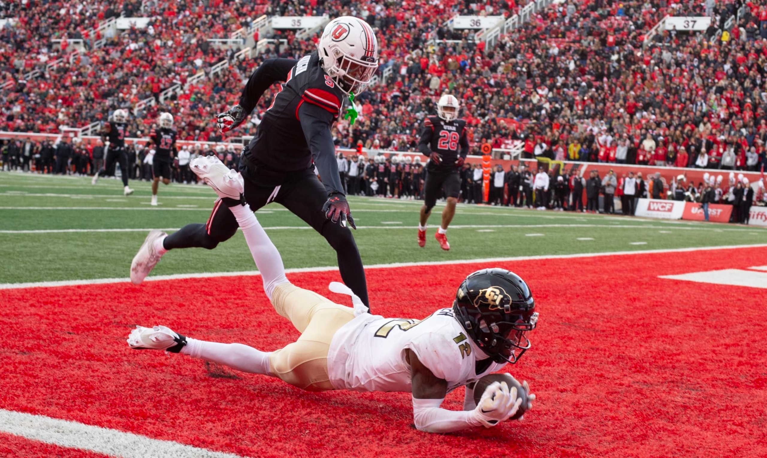 SALT LAKE CITY, UT - NOVEMBER 25:  Hunter Travis #12 of the Colorado Buffaloes can't hold on to a pass in the endzone as he is covered by Zemaiah Vaughn #5 of the Utah Utes during the first half of their game at Rice Eccles Stadium on November 25, 2023 in Salt Lake City, Utah.  (Photo by Chris Gardner/Getty Images)