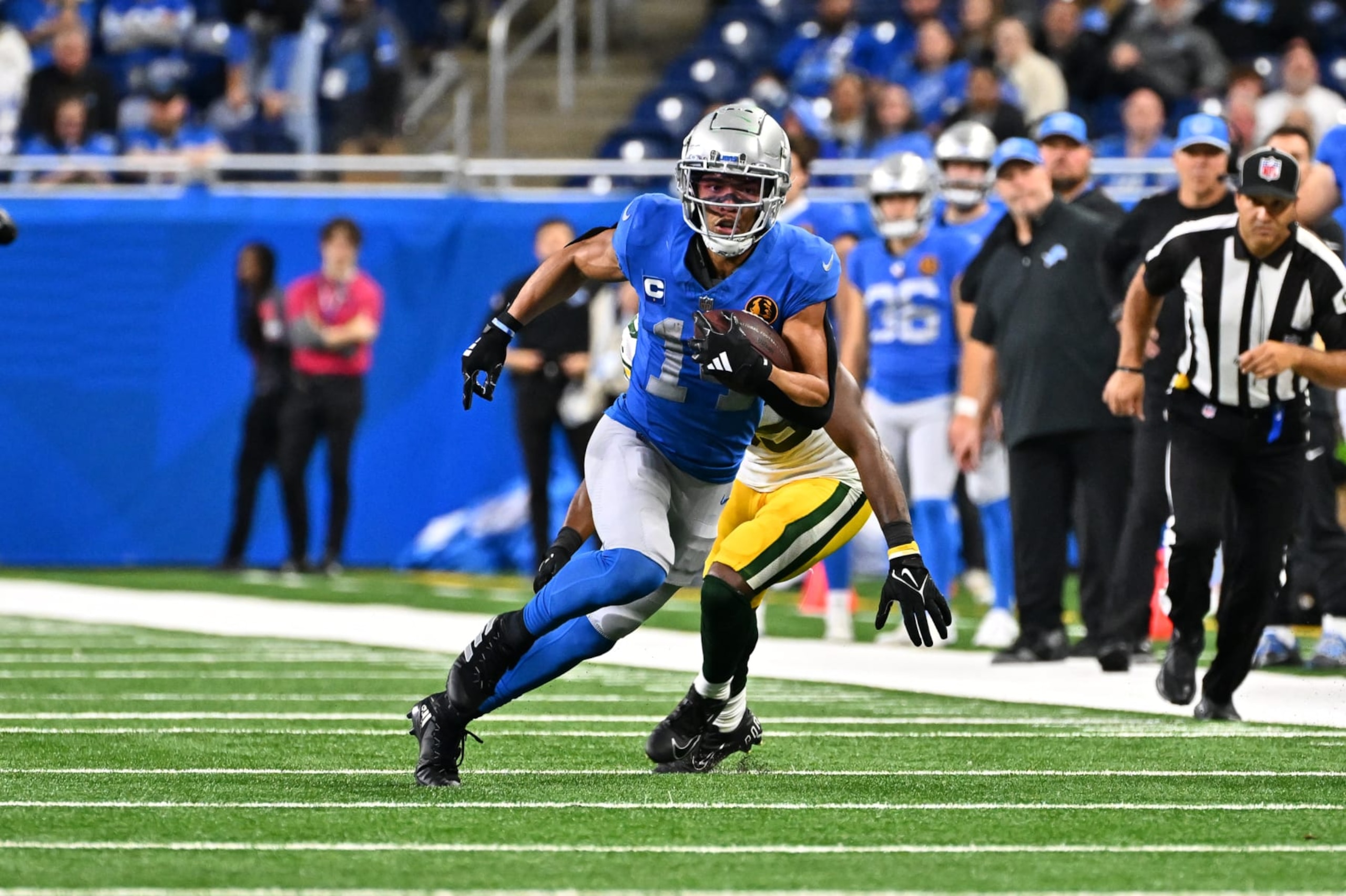 DETROIT, MI - NOVEMBER 23: Detroit Lions wide receiver Amon-Ra St. Brown (14) runs upfield with a catch for a first down during the Detroit Lions versus the Green Bay Packers game on Thursday November 23, 2023 at Ford Field in Detroit, MI. (Photo by Steven King/Icon Sportswire via Getty Images)