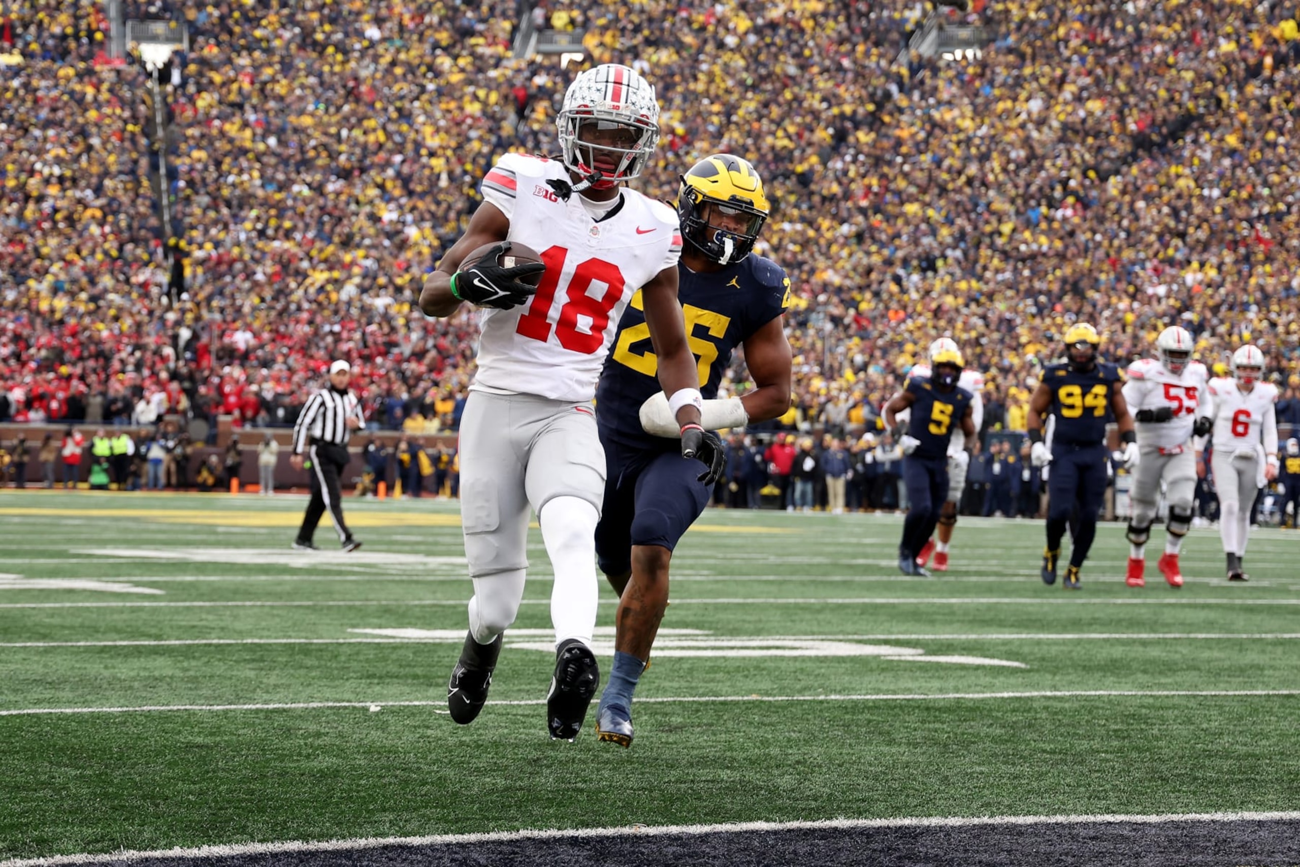 ANN ARBOR, MICHIGAN - NOVEMBER 25: Marvin Harrison Jr. #18 of the Ohio State Buckeyes scores a touchdown against Junior Colson #25 of the Michigan Wolverines during the fourth quarter in the game at Michigan Stadium on November 25, 2023 in Ann Arbor, Michigan. (Photo by Ezra Shaw/Getty Images)