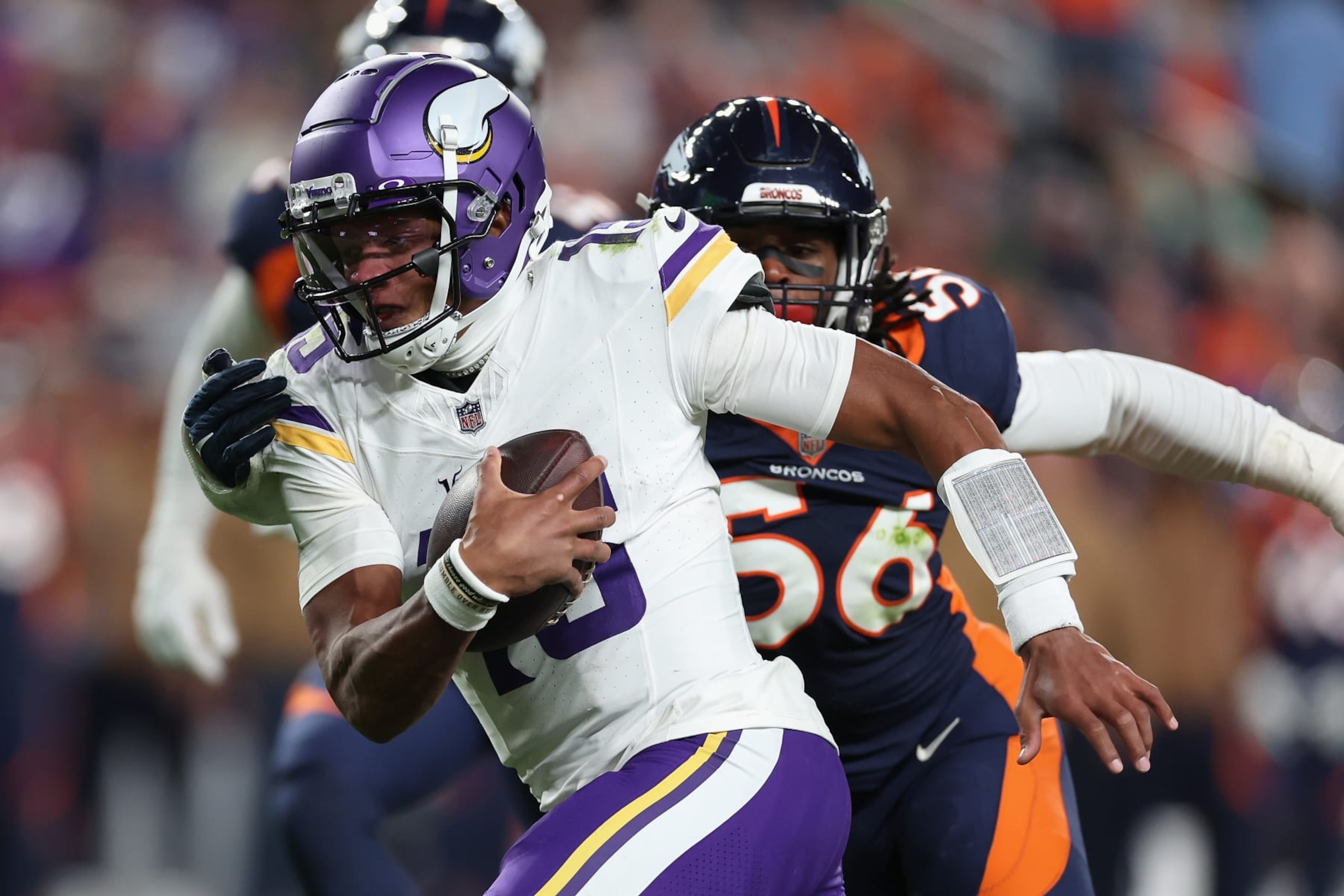 DENVER, COLORADO - NOVEMBER 19: Quarterback Joshua Dobbs #15 of the Minnesota Vikings carries the football past linebacker Baron Browning #56 of the Denver Broncos en route to scoring a 10-yard rushing touchdown during the third quarter of the NFL game at Empower Field At Mile High on November 19, 2023 in Denver, Colorado. (Photo by Matthew Stockman/Getty Images)