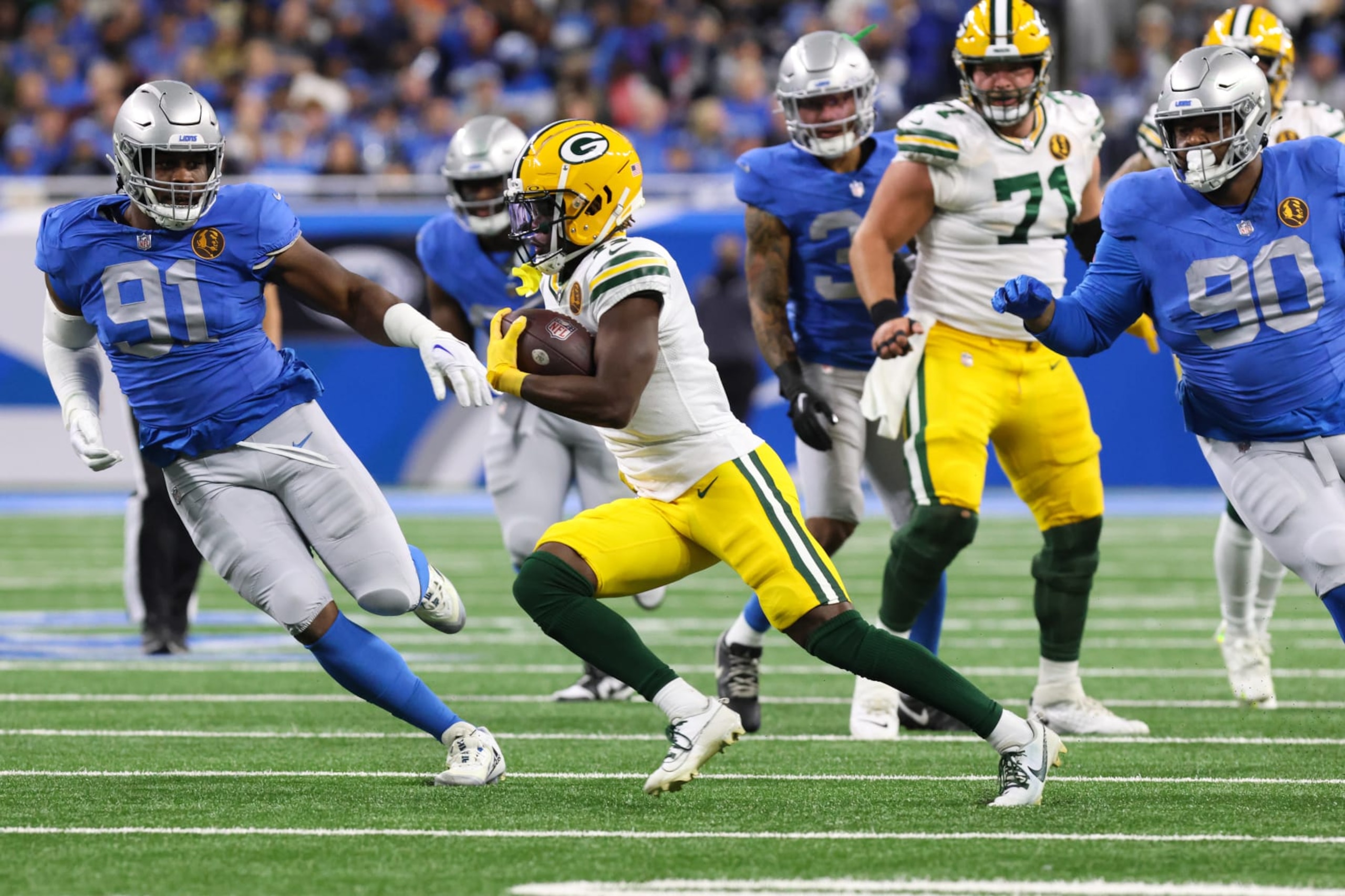 DETROIT, MI - NOVEMBER 23:  Green Bay Packers wide receiver Jayden Reed (11), center, runs with the ball after catching a pass while Detroit Lions defensive tackle Levi Onwuzurike (91) and Detroit Lions defensive tackle Quinton Bohanna (90) pursue his during a traditional Thanksgiving Day NFL football game between the Green Bay Packers and the Detroit Lions on November 23, 2023 at Ford Field in Detroit, Michigan.  (Photo by Scott W. Grau/Icon Sportswire via Getty Images)