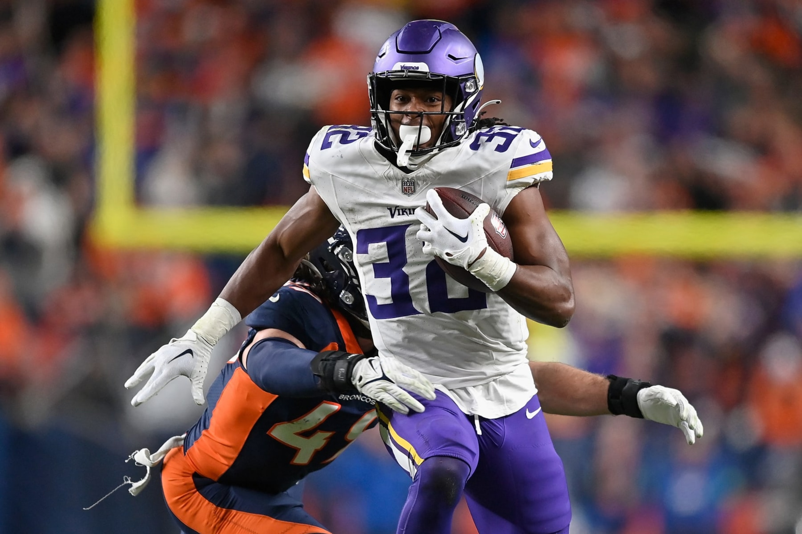 DENVER, COLORADO - NOVEMBER 19: Running back Ty Chandler #32 of the Minnesota Vikings makes a reception past linebacker Alex Singleton #49 of the Denver Broncos during the fourth quarter of the NFL game at Empower Field At Mile High on November 19, 2023 in Denver, Colorado. The Broncos defeated the Vikings 21-20.  (Photo by Dustin Bradford/Getty Images)