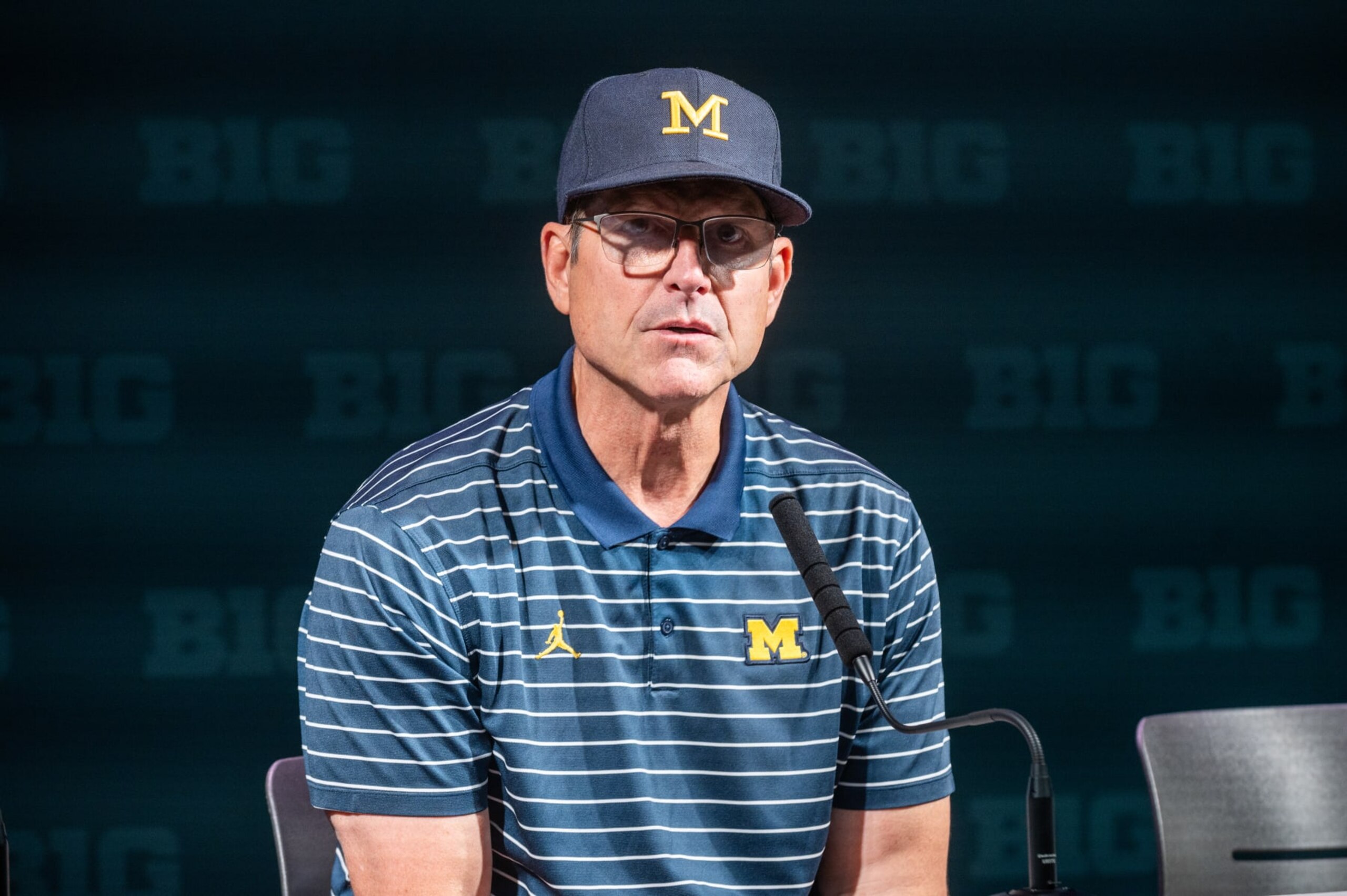 EAST LANSING, MICHIGAN - OCTOBER 21: Head coach Jim Harbaugh of the Michigan Wolverines speaks to media during the post game press conference after a college football game against the Michigan State Spartans at Spartan Stadium on October 21, 2023 in East Lansing, Michigan. The Michigan Wolverines won the game 49-0. (Photo by Aaron J. Thornton/Getty Images)