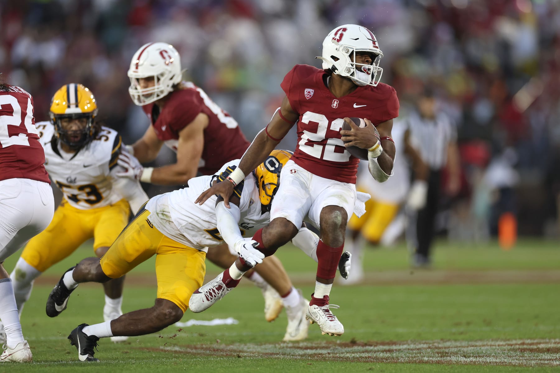 STANFORD, CALIFORNIA - NOVEMBER 18: E.J. Smith #22 of the Stanford Cardinal is tackled by Craig Woodson #2 of the California Golden Bears in the first half at Stanford Stadium on November 18, 2023 in Stanford, California. (Photo by Ezra Shaw/Getty Images)