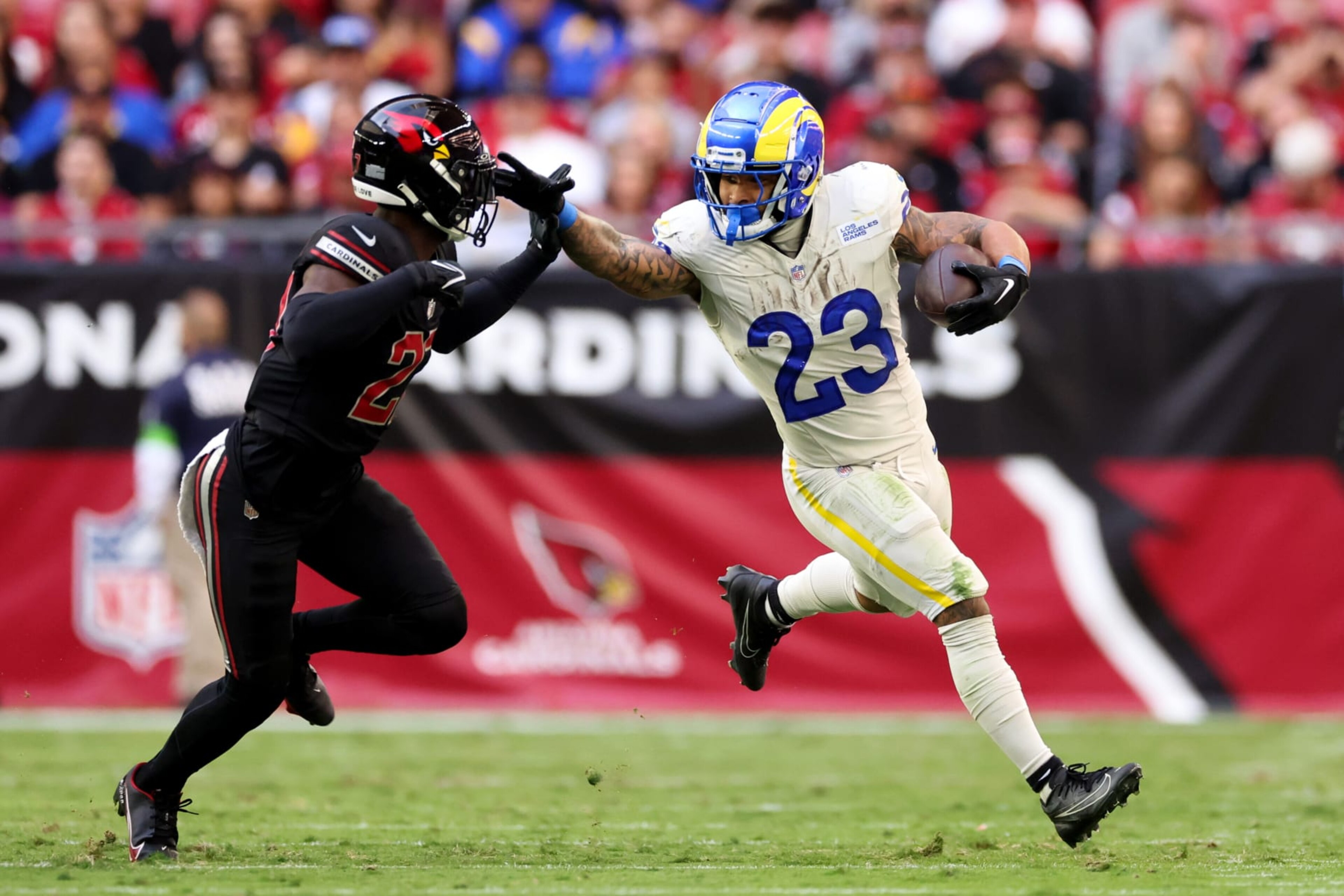 GLENDALE, ARIZONA - NOVEMBER 26: Kyren Williams #23 of the Los Angeles Rams stiff arms Divaad Wilson #27 of the Arizona Cardinals during the second quarter at State Farm Stadium on November 26, 2023 in Glendale, Arizona. (Photo by Christian Petersen/Getty Images)