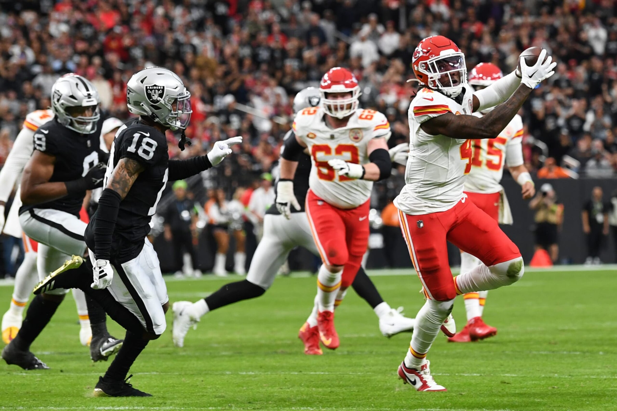LAS VEGAS, NEVADA - NOVEMBER 26: Rashee Rice #4 of the Kansas City Chiefs catches a pass in front of Jack Jones #18 of the Las Vegas Raiders during the second quarter at Allegiant Stadium on November 26, 2023 in Las Vegas, Nevada. (Photo by Candice Ward/Getty Images)