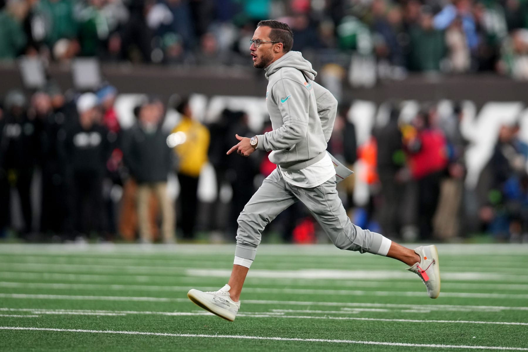 EAST RUTHERFORD, NEW JERSEY - NOVEMBER 24: Head coach Mike McDaniel of the Miami Dolphins runs on the field to the locker room after Jevon Holland #8 scored a 99 yard touchdown off an interception against the New York Jets during the second quarter in the game at MetLife Stadium on November 24, 2023 in East Rutherford, New Jersey. (Photo by Mike Stobe/Getty Images)