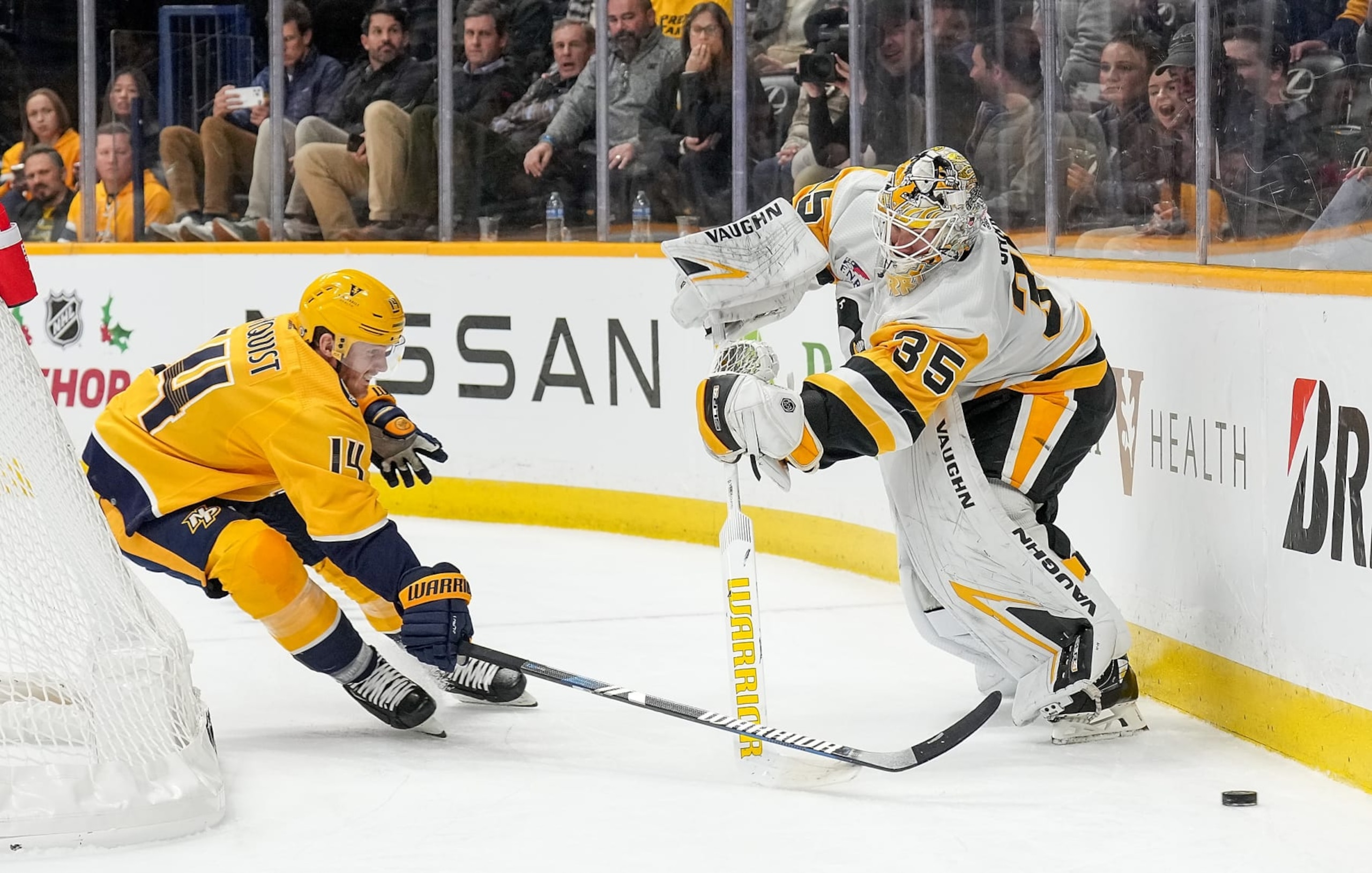 NASHVILLE, TENNESSEE - NOVEMBER 28: Gustav Nyquist #14 of the Nashville Predators pokes the puck away from Tristan Jarry #35 of the Pittsburgh Penguins during an NHL game at Bridgestone Arena on November 28, 2023 in Nashville, Tennessee. (Photo by John Russell/NHLI via Getty Images)