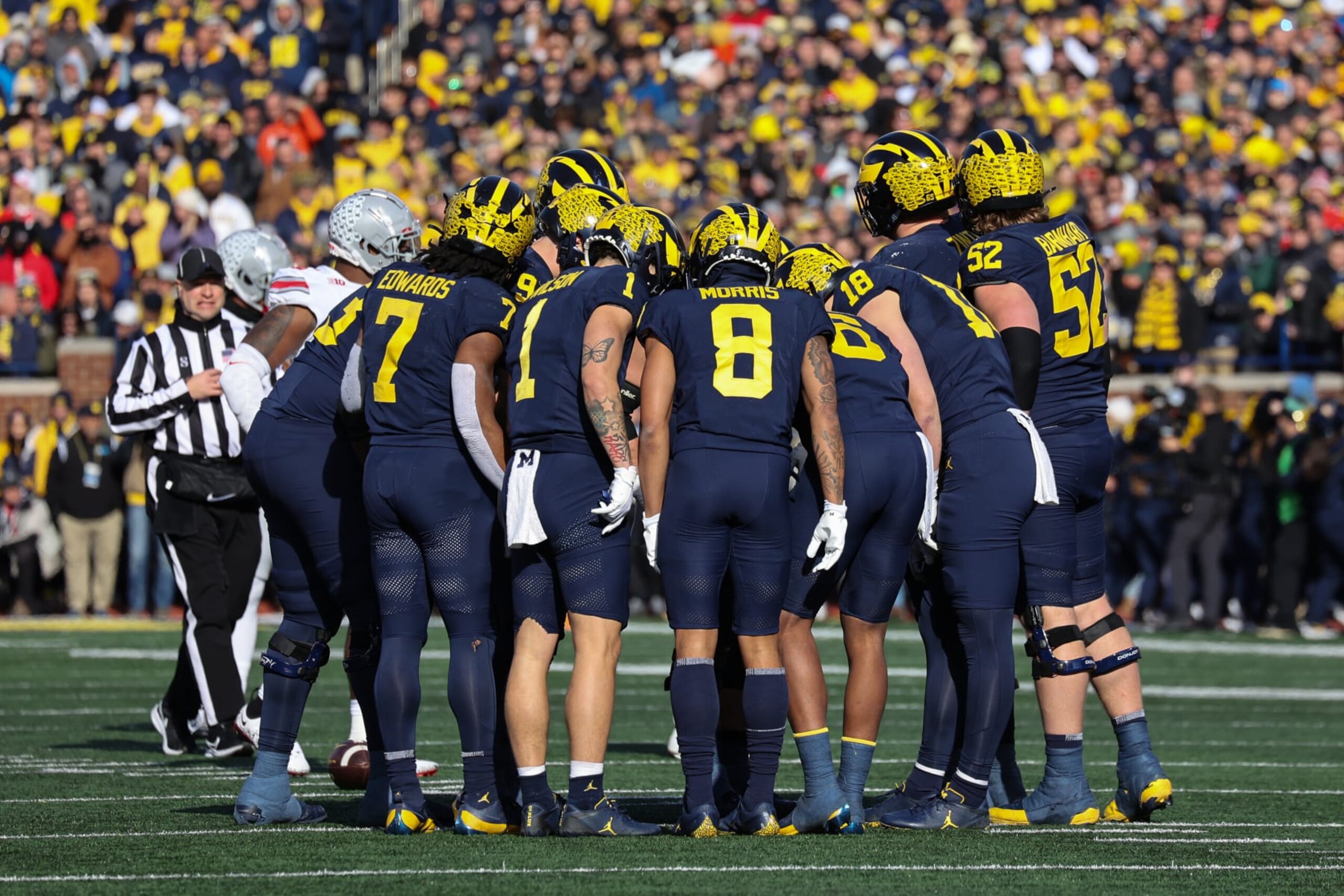 ANN ARBOR, MI - NOVEMBER 25:  Michigan offensive players huddle together as a play is called during a regular season Big Ten Conference college football game between the Ohio State Buckeyes and the Michigan Wolverines on November 25, 2023 at Michigan Stadium in Ann Arbor, Michigan. (Photo by Scott W. Grau/Icon Sportswire via Getty Images)
