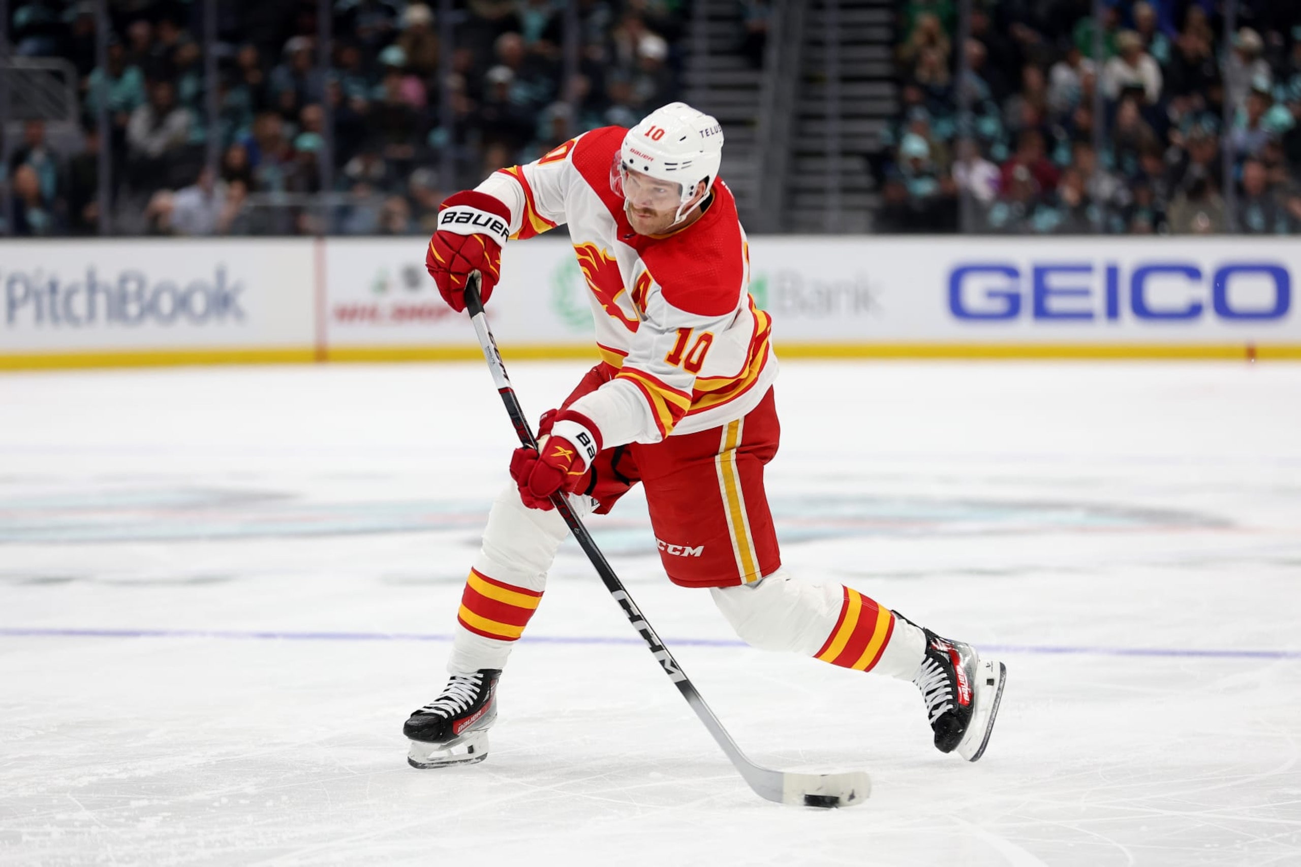 SEATTLE, WASHINGTON - NOVEMBER 20: Jonathan Huberdeau #10 of the Calgary Flames shoots and scores a powerplay goal against the Seattle Kraken during the first period at Climate Pledge Arena on November 20, 2023 in Seattle, Washington. (Photo by Steph Chambers/Getty Images)