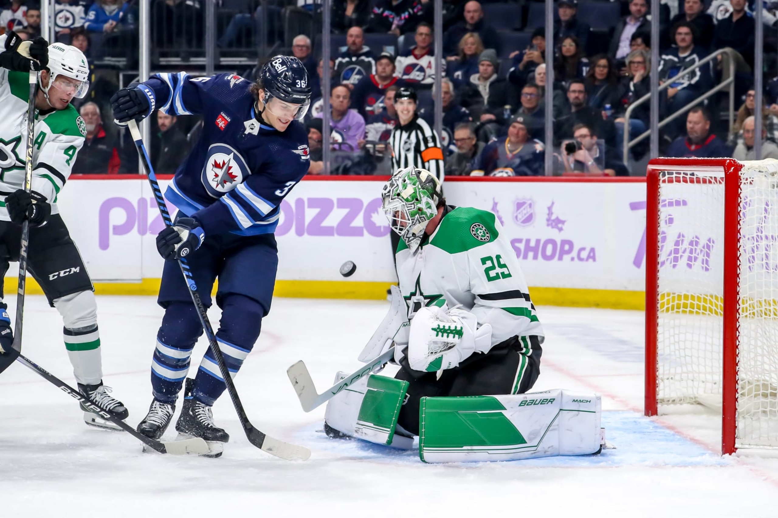 WINNIPEG, CANADA - NOVEMBER 28: Morgan Barron #36 of the Winnipeg Jets crashes the net looking for a rebound as goaltender Jake Oettinger #29 of the Dallas Stars guards the crease during third period action at the Canada Life Centre on November 28, 2023 in Winnipeg, Manitoba, Canada. (Photo by Darcy Finley/NHLI via Getty Images)