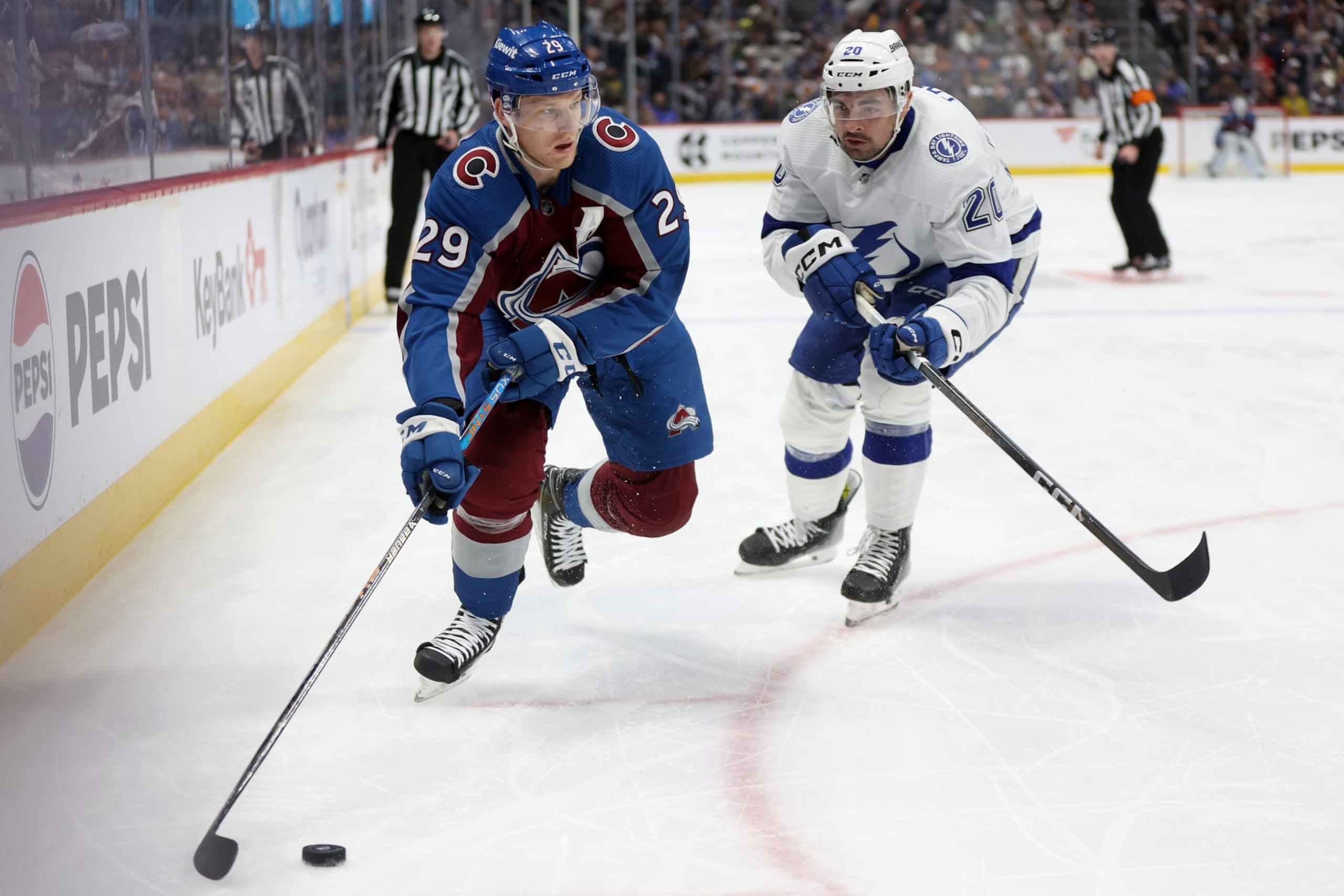 DENVER, COLORADO - NOVEMBER 27: Nathan MacKinnon #29 of the Colorado Avalanche clears the puck out against Brayden Point #21 of the Tampa Bay Lightening in the second period at Ball Arena on November 27, 2023 in Denver, Colorado. (Photo by Matthew Stockman/Getty Images)