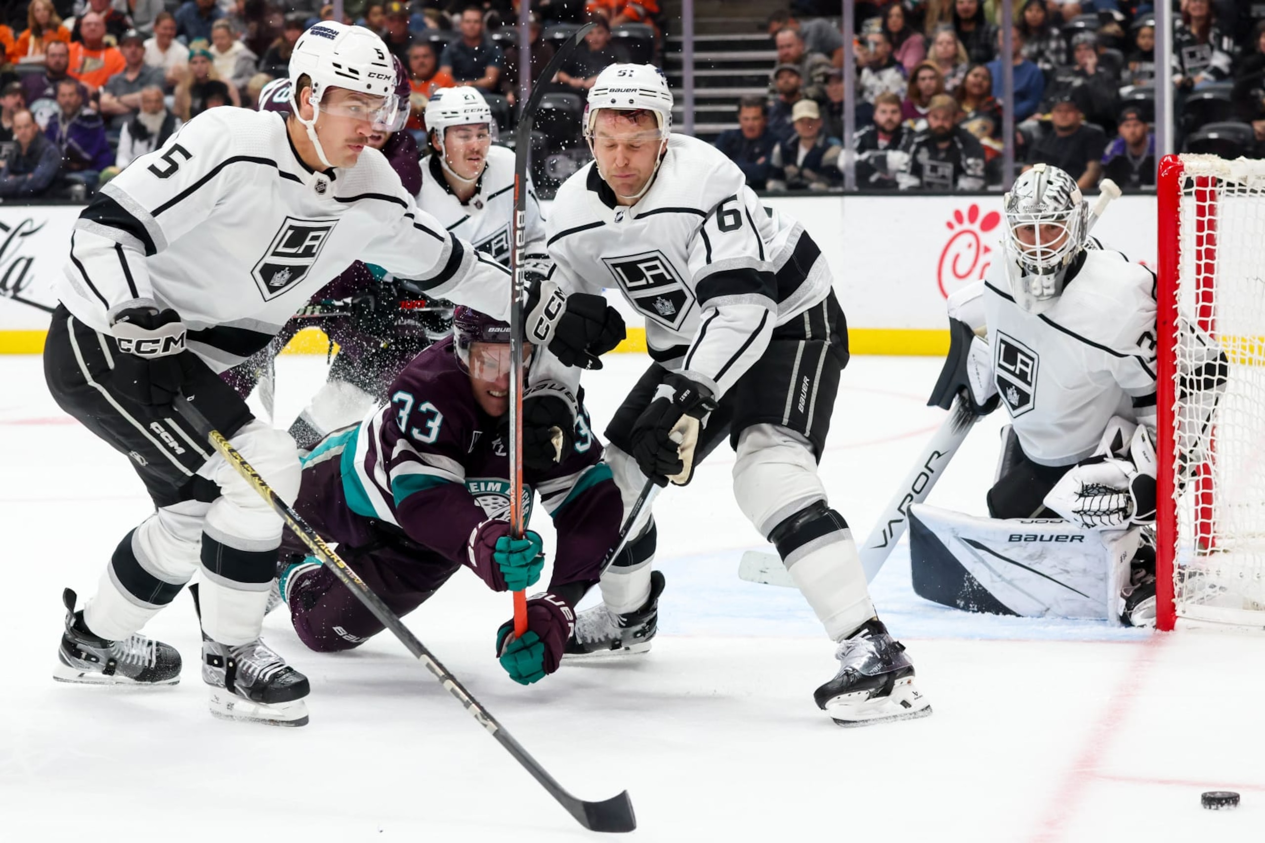ANAHEIM, CA - NOVEMBER 24: Andreas Englund #5 of the Los Angeles Kings, Jakob Silfverberg #33 of the Anaheim Ducks and Trevor Lewis #61 of the Los Angeles Kings battle for the puck during the third period at Honda Center on November 24, 2023 in Anaheim, California. (Photo by Debora Robinson/NHLI via Getty Images)