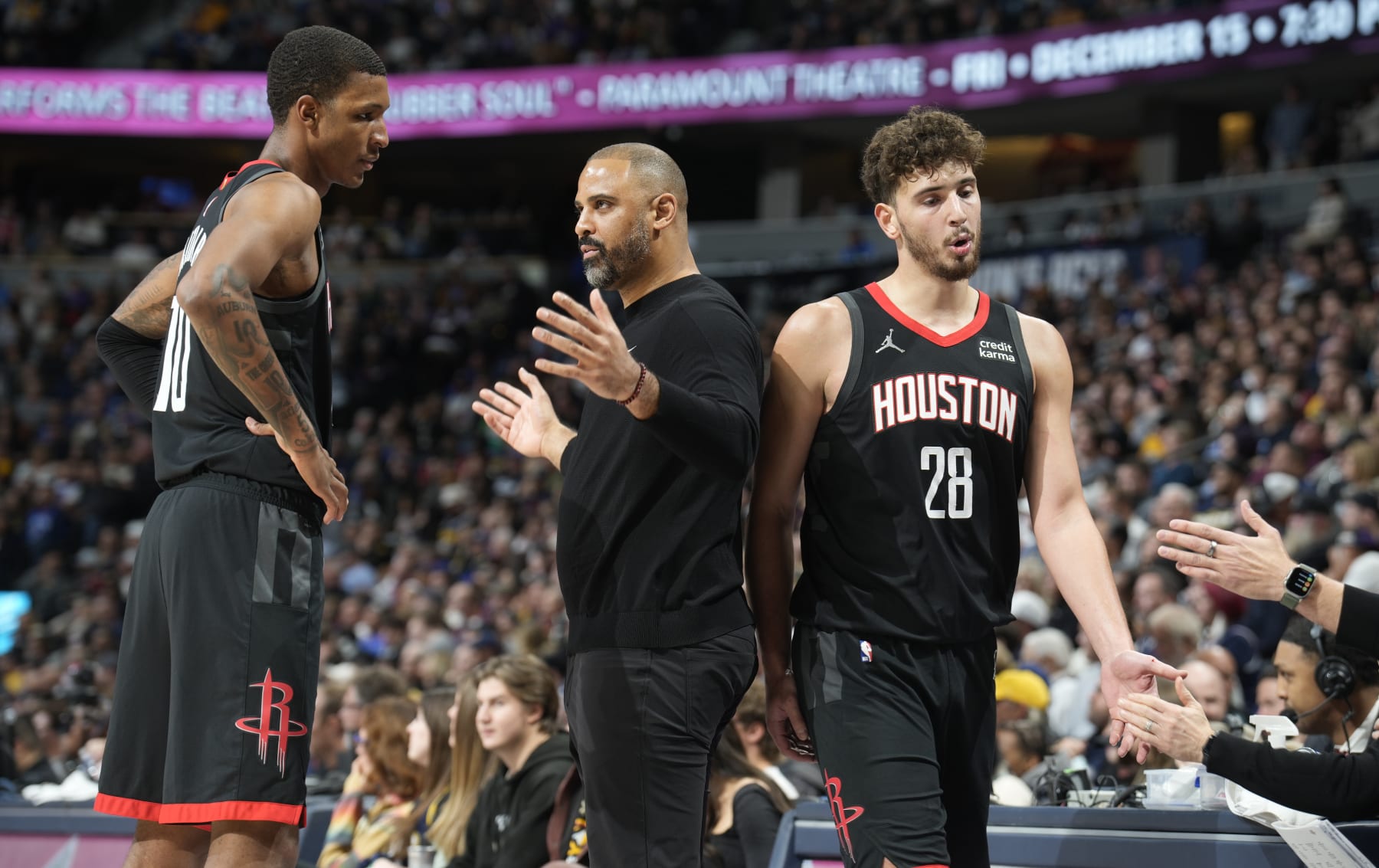 Houston Rockets head coach Ime Udoka, center, talks with forward Jabari Smith Jr., left, as center Alperen Sengun (28) heads to the bench during a time out in the second half of an NBA basketball game against the Denver Nuggets on Wednesday, Nov. 29, 2023, in Denver. (AP Photo/David Zalubowski)