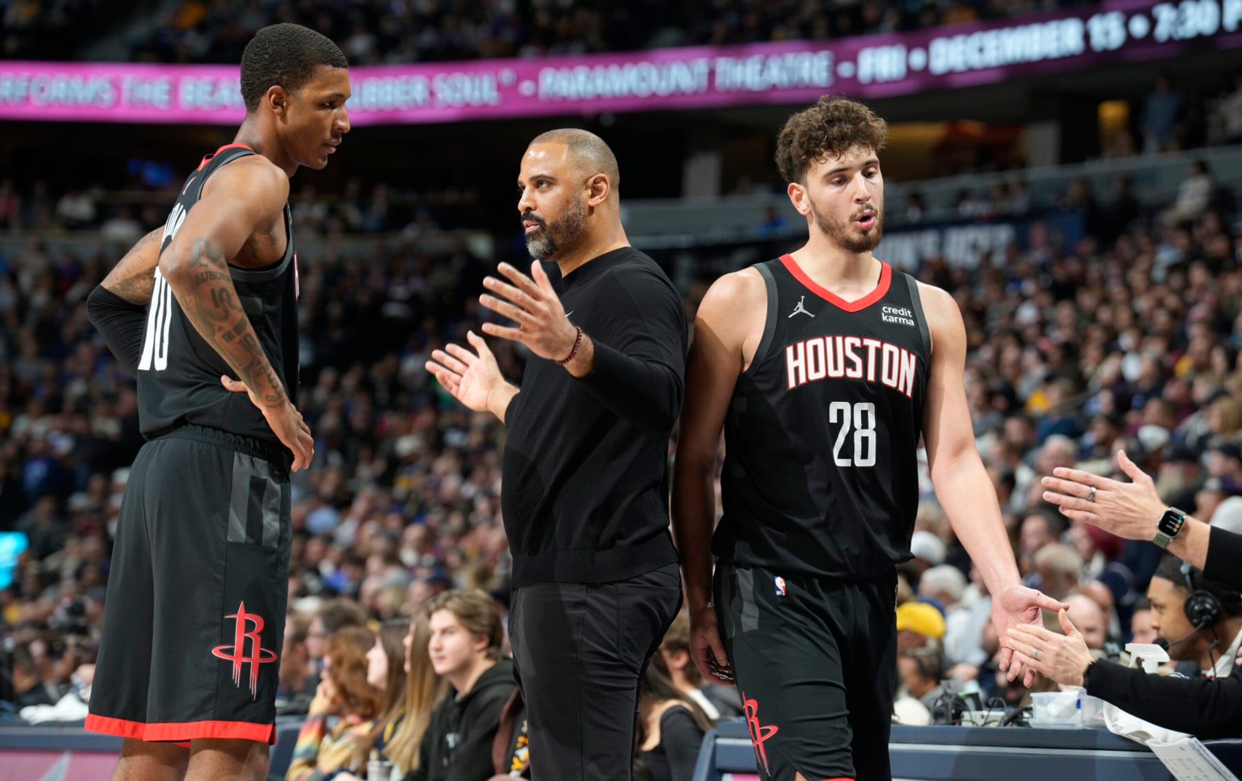 Houston Rockets head coach Ime Udoka, center, talks with forward Jabari Smith Jr., left, as center Alperen Sengun (28) heads to the bench during a time out in the second half of an NBA basketball game against the Denver Nuggets on Wednesday, Nov. 29, 2023, in Denver. (AP Photo/David Zalubowski)