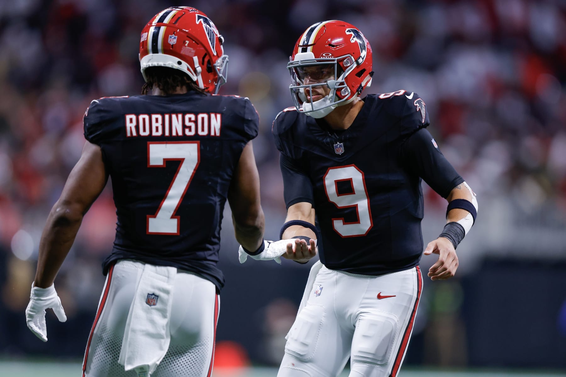 ATLANTA, GEORGIA - NOVEMBER 26: Bijan Robinson #7 of the Atlanta Falcons celebrates with Desmond Ridder #9 after scoring a touchdown in the second quarter of the game against the New Orleans Saints at Mercedes-Benz Stadium on November 26, 2023 in Atlanta, Georgia. (Photo by Todd Kirkland/Getty Images)