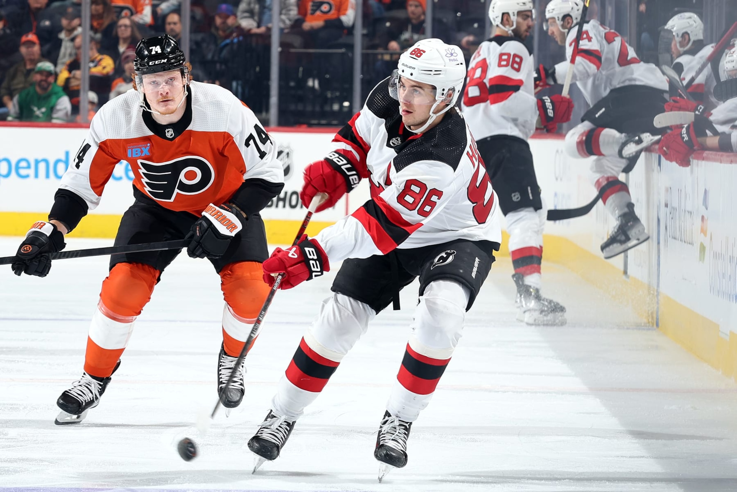 PHILADELPHIA, PENNSYLVANIA - NOVEMBER 30: Jack Hughes #86 of the New Jersey Devils passes the puck past Owen Tippett #74 of the Philadelphia Flyers during the first period at the Wells Fargo Center on November 30, 2023 in Philadelphia, Pennsylvania. (Photo by Tim Nwachukwu/Getty Images)