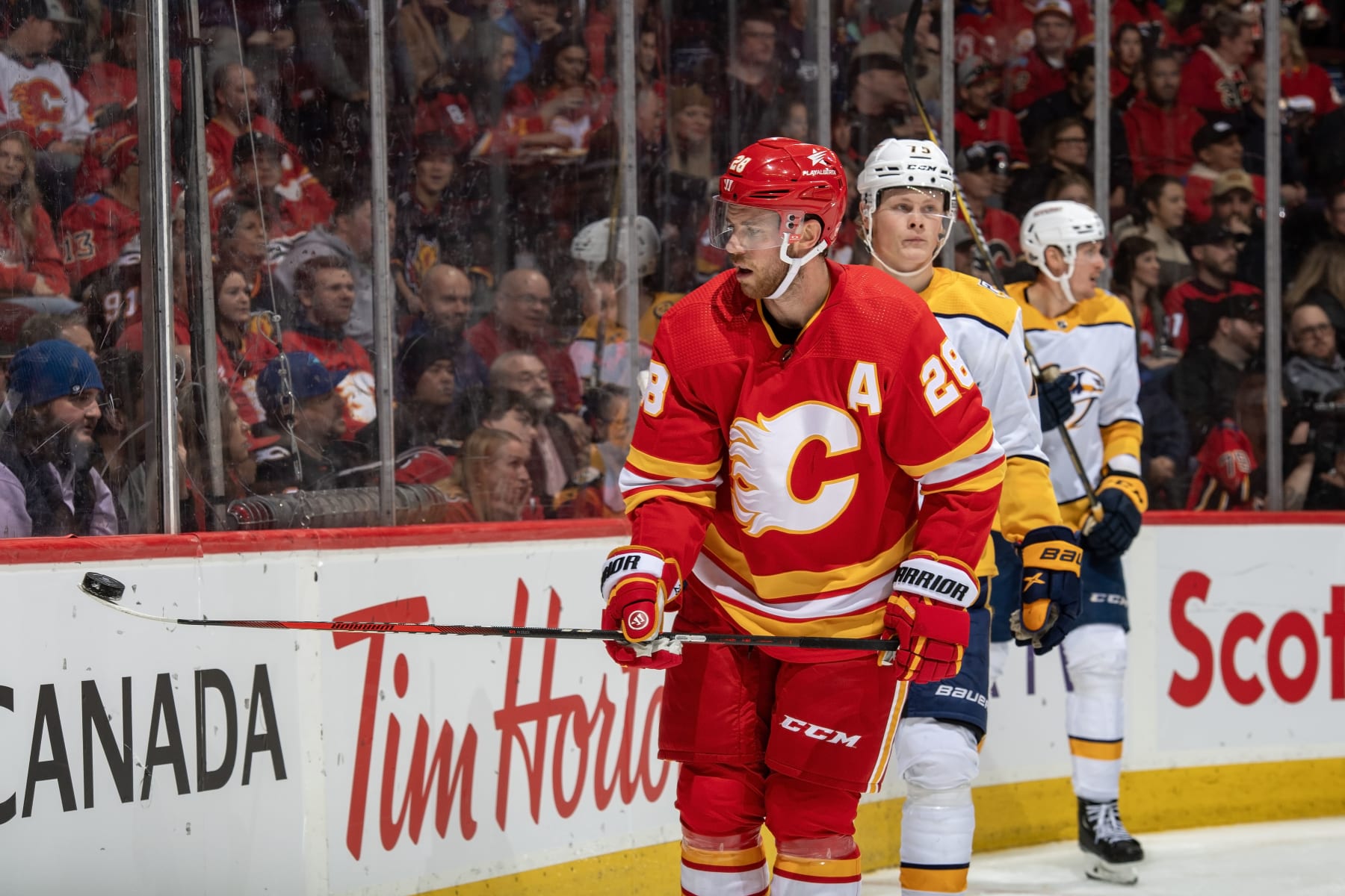 CALGARY, AB - NOVEMBER 7: Elias Lindholm #28 of the Calgary Flames collects the puck against the Nashville Predators at Scotiabank Saddledome on November 7, 2023 in Calgary, Alberta, Canada. (Photo by Terence Leung/NHLI via Getty Images)