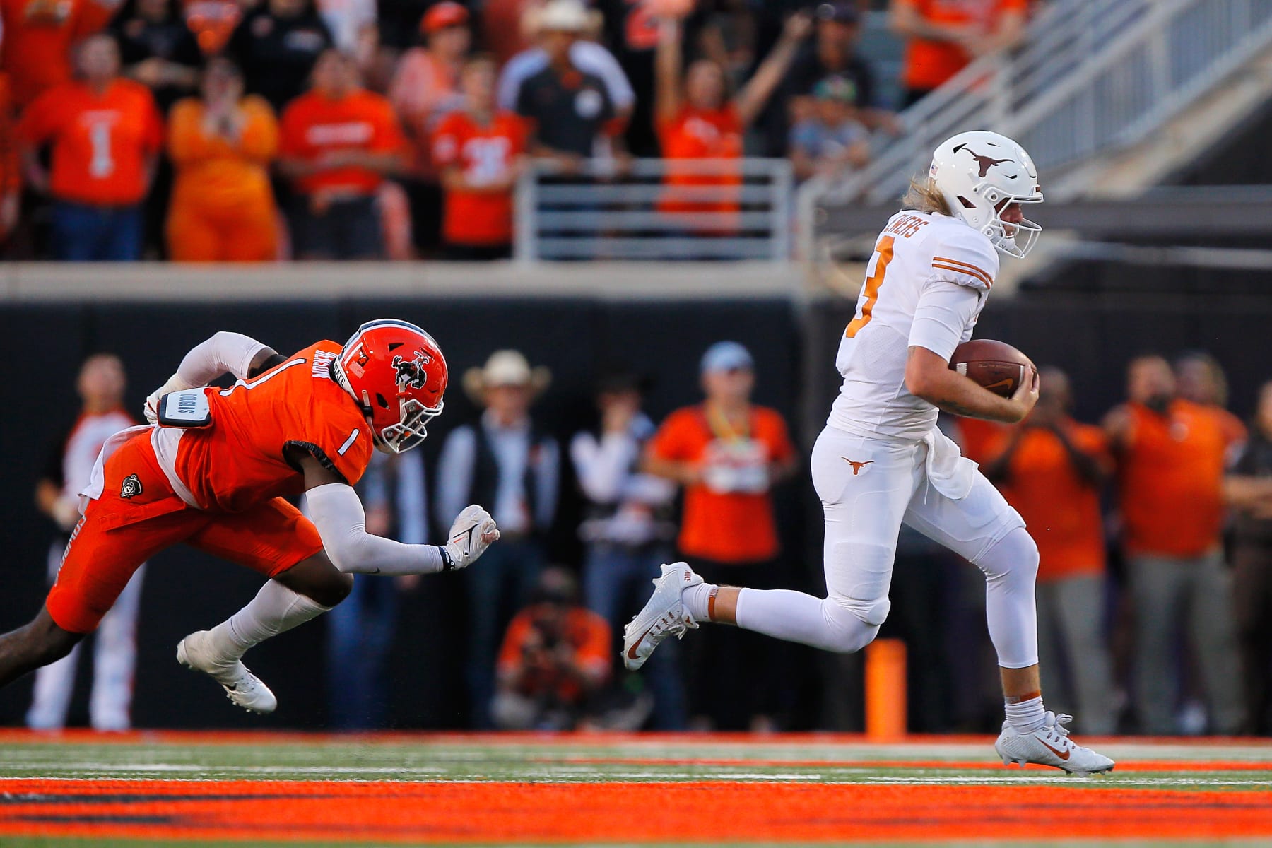 STILLWATER, OK - OCTOBER 22:  Quarterback Quinn Ewers #3 of the Texas Longhorns runs for a 33-yard gain against linebacker Xavier Benson #1 of the Oklahoma State Cowboys on a play called back for holding in the fourth quarter at Boone Pickens Stadium on October 22, 2022 in Stillwater, Oklahoma.  Oklahoma State won 41-34.  (Photo by Brian Bahr/Getty Images)