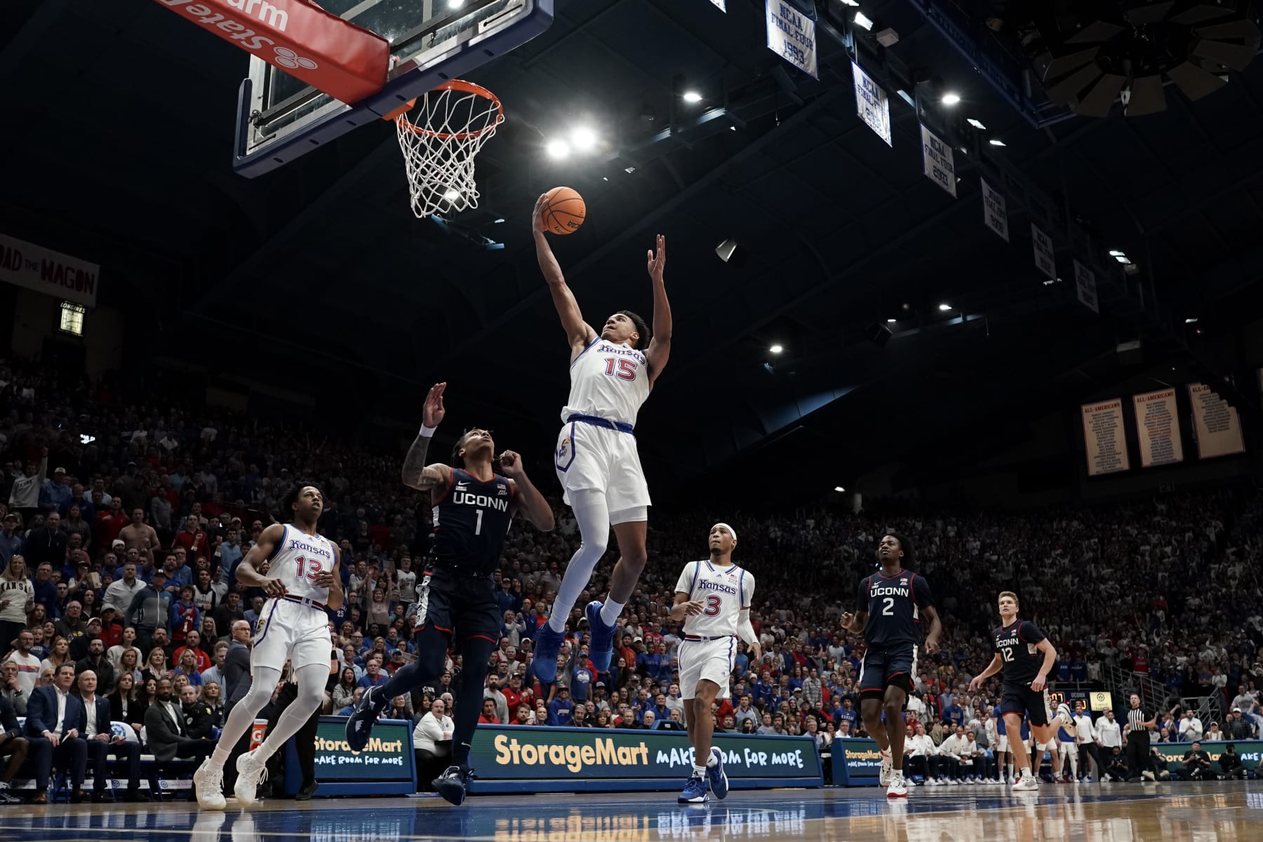 Kansas guard Kevin McCullar Jr. (15) shoots over UConn guard Solomon Ball (1) during the first half of an NCAA college basketball game Friday, Dec. 1, 2023, in Lawrence, Kan. (AP Photo/Charlie Riedel)