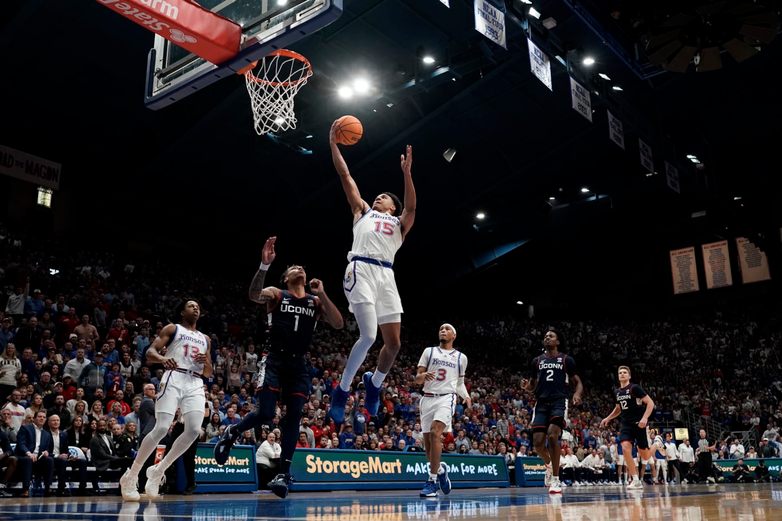 Kansas guard Kevin McCullar Jr. (15) shoots over UConn guard Solomon Ball (1) during the first half of an NCAA college basketball game Friday, Dec. 1, 2023, in Lawrence, Kan. (AP Photo/Charlie Riedel)