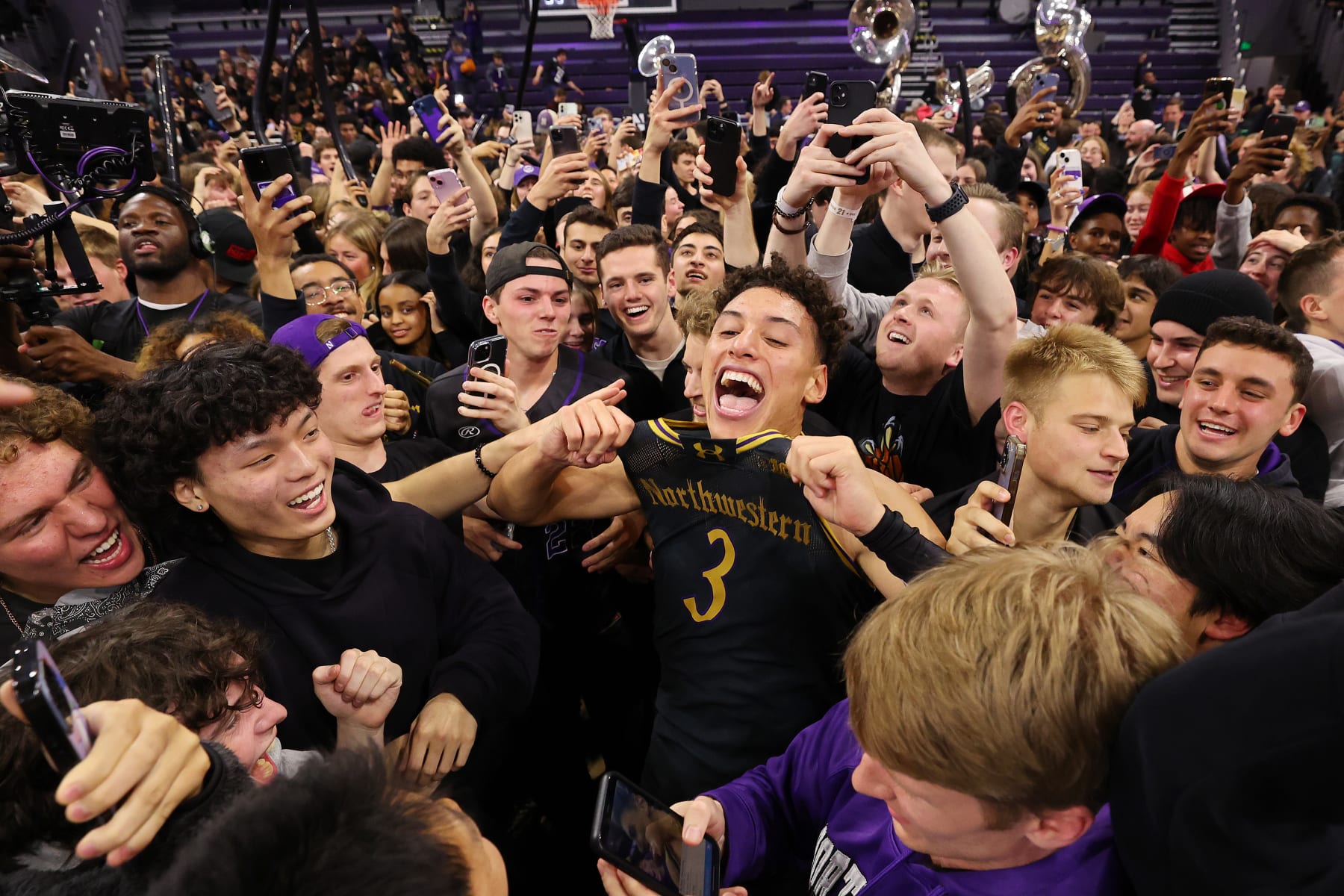 EVANSTON, ILLINOIS - DECEMBER 01: Ty Berry #3 of the Northwestern Wildcats celebrate with fans after defeating the Purdue Boilermakers 92-88 in overtime at Welsh-Ryan Arena on December 01, 2023 in Evanston, Illinois. (Photo by Michael Reaves/Getty Images)