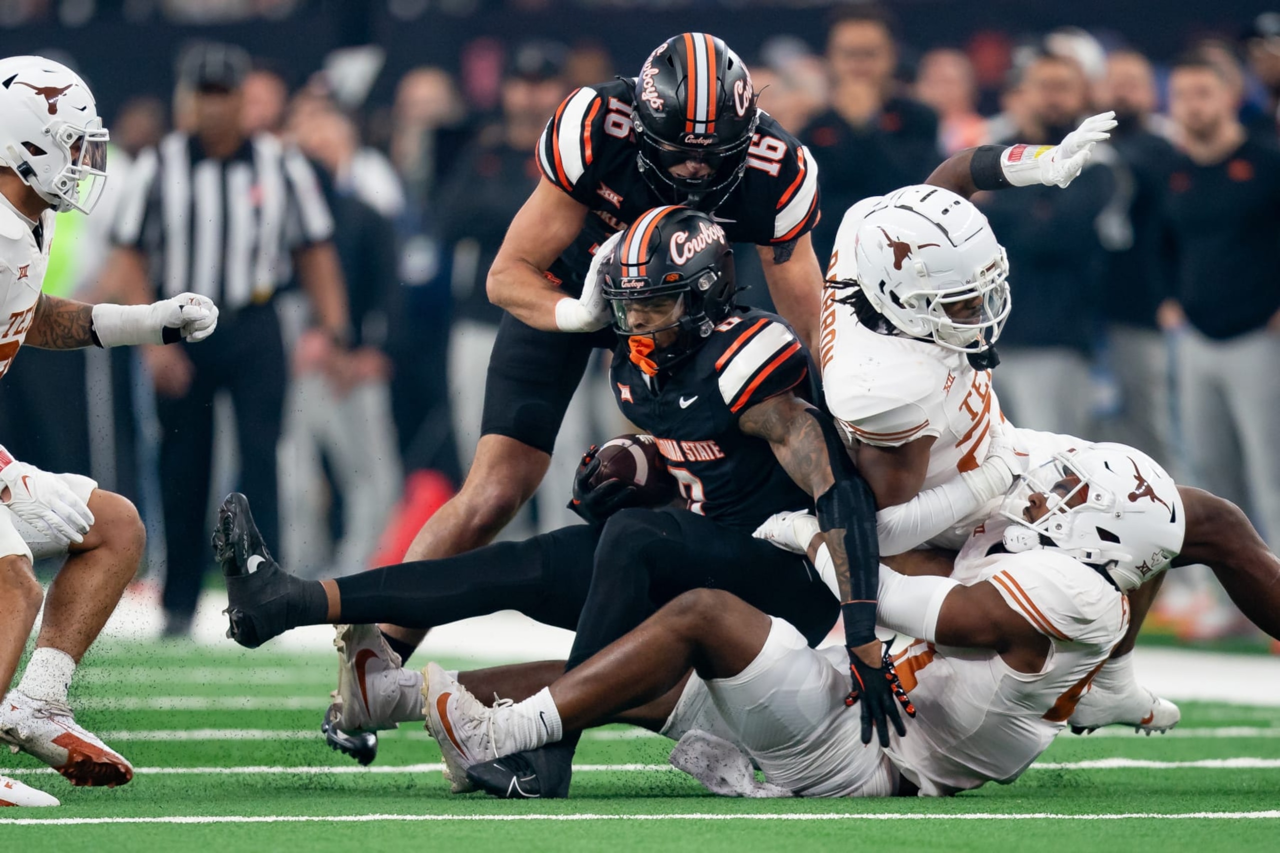ARLINGTON, TX - DECEMBER 02: Oklahoma State Cowboys running back Ollie Gordon II (0) is tackled during the Big 12 Championship game between the Texas Longhorns and the Oklahoma State Cowboys   on December 02, 2023 at AT&T Stadium in Arlington, TX. (Photo by Chris Leduc/Icon Sportswire via Getty Images)
