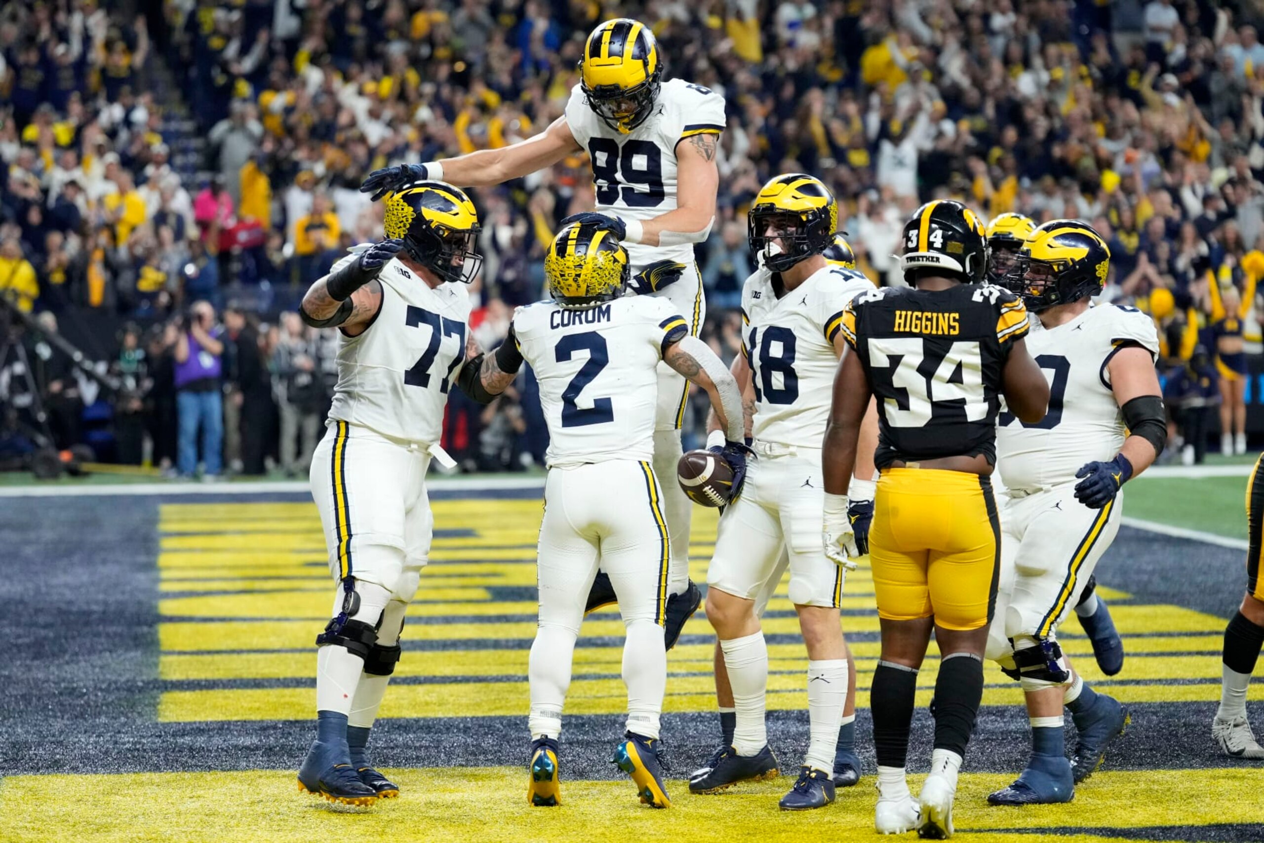 Michigan running back Blake Corum (2) celebrates with teammates after scoring on a 2-yard touchdown run during the first half of the Big Ten championship NCAA college football game against Iowa, Saturday, Dec. 2, 2023, in Indianapolis. (AP Photo/AJ Mast)