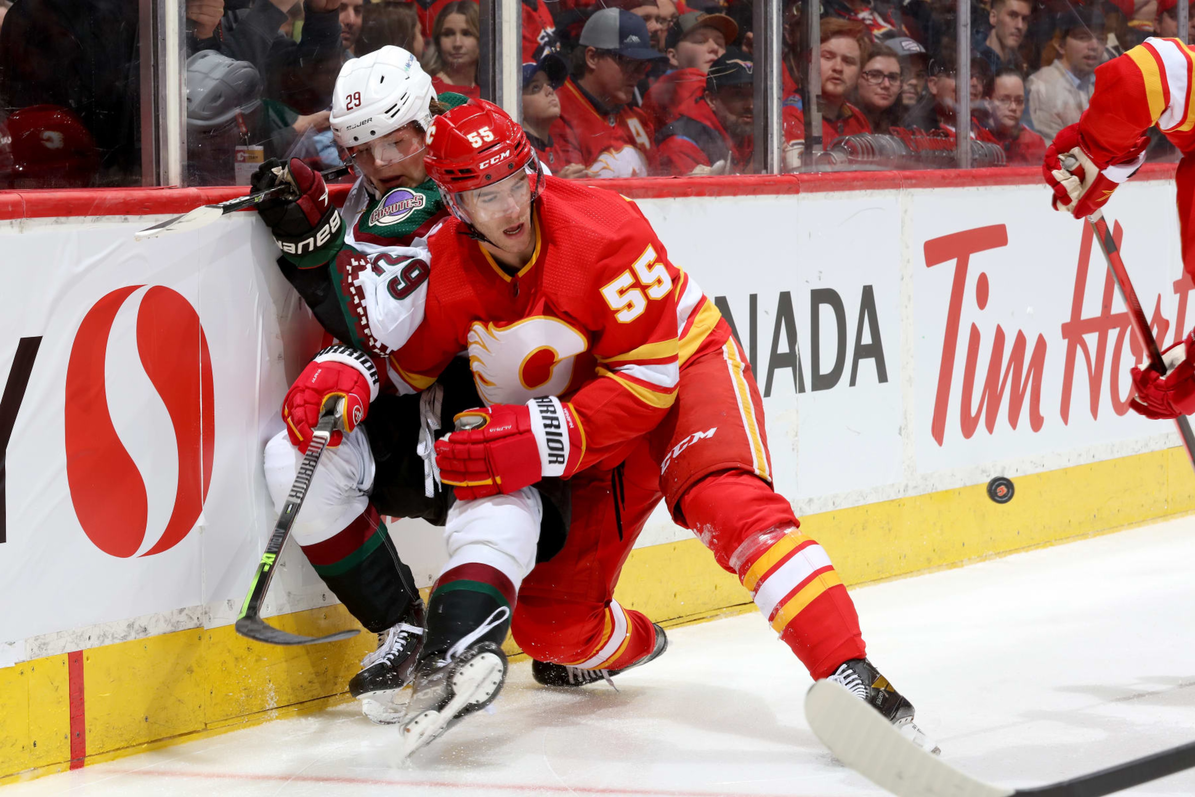 CALGARY, ALBERTA - APRIL 16: Noah Hanifin #55 of the Calgary Flames skates against Barrett Hayton #29 of the Arizona Coyotes at Scotiabank Saddledome on April 16, 2022 in Calgary, Alberta. (Photo by Gerry Thomas/NHLI via Getty Images)