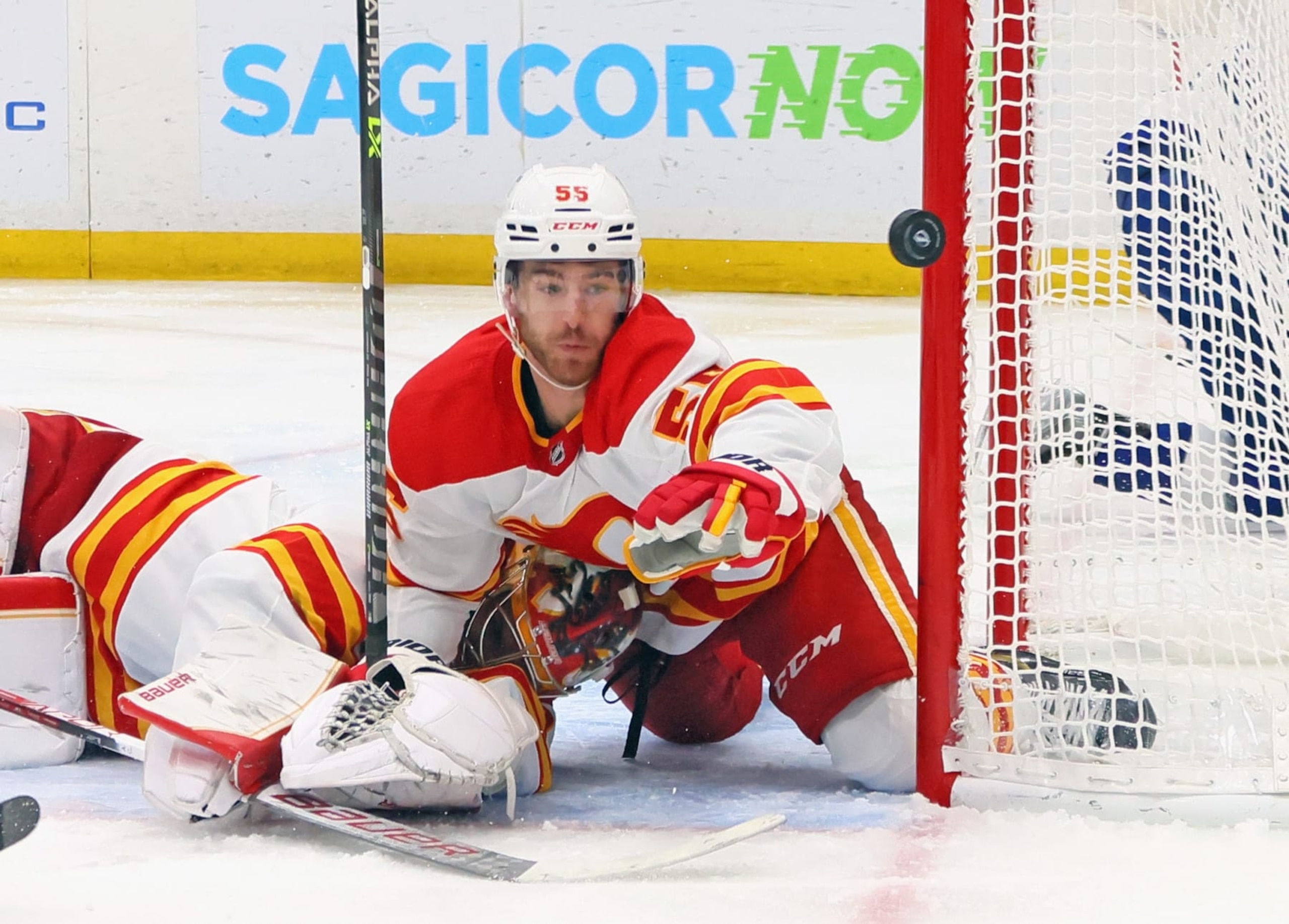 TAMPA, FLORIDA - JANUARY 06: Noah Hanifin #55 and Dan Vladar #80 of the Calgary Flames make the second period stop against the Tampa Bay Lightning at the Amalie Arena on January 06, 2022 in Tampa, Florida. (Photo by Bruce Bennett/Getty Images)