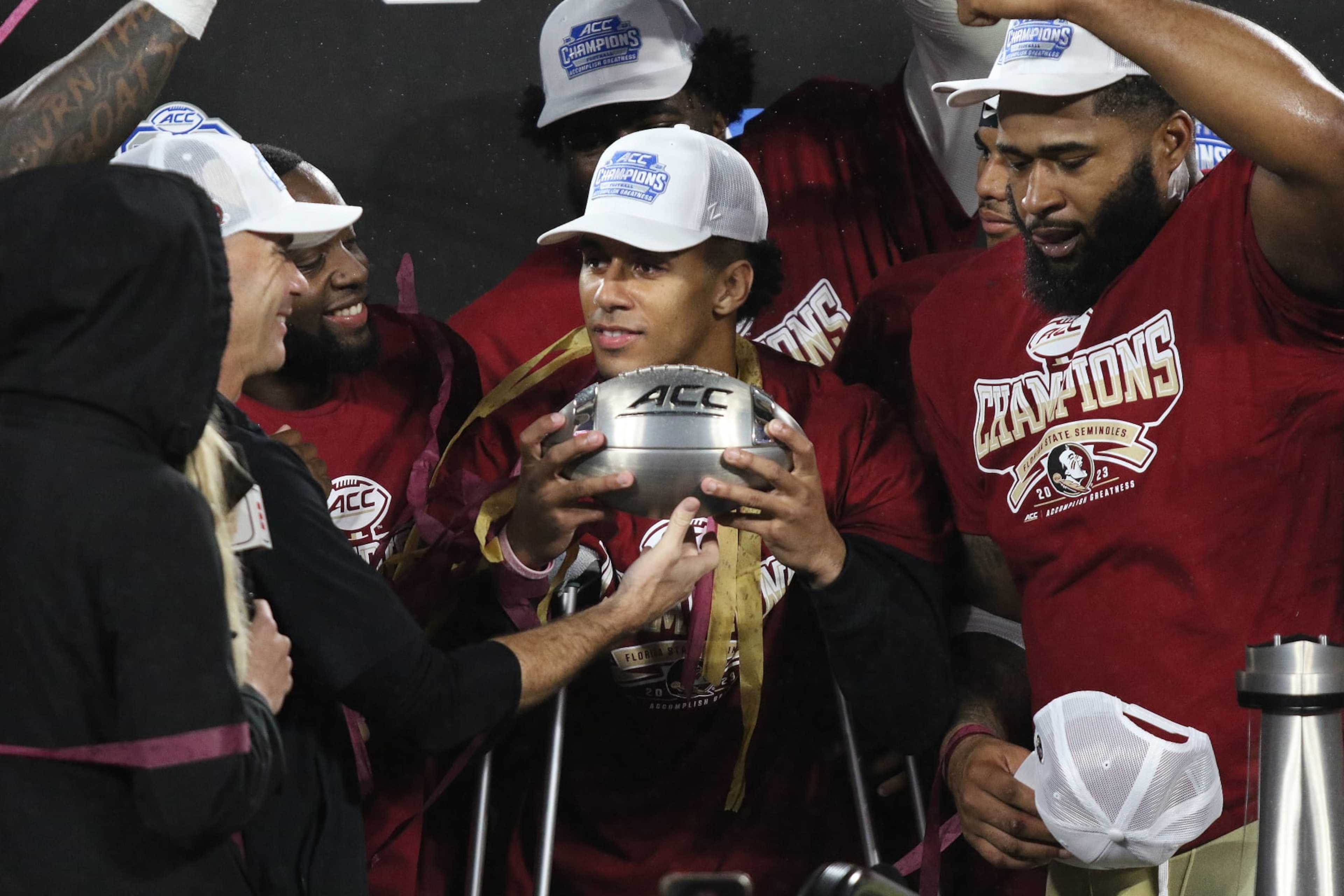 CHARLOTTE, NC - DECEMBER 02: Florida State Seminoles quarterback Jordan Travis (13) a day after having surgery holds the football trophy with his teammates during the ACC Football Championship Game between the Louisville Cardinals and the Florida State Seminoles on December 2, 2023 at Bank of America Stadium in Charlotte, N.C. (Photo by John Byrum/Icon Sportswire via Getty Images) CHARLOTTE, NC - DECEMBER 02: Florida State Seminoles quarterback Jordan Travis (13) a day after having surgery holds the football trophy with his teammates during the ACC Football Championship Game between the Louisville Cardinals and the Florida State Seminoles on December 2, 2023 at Bank of America Stadium in Charlotte, N.C. (Photo by John Byrum/Icon Sportswire via Getty Images)