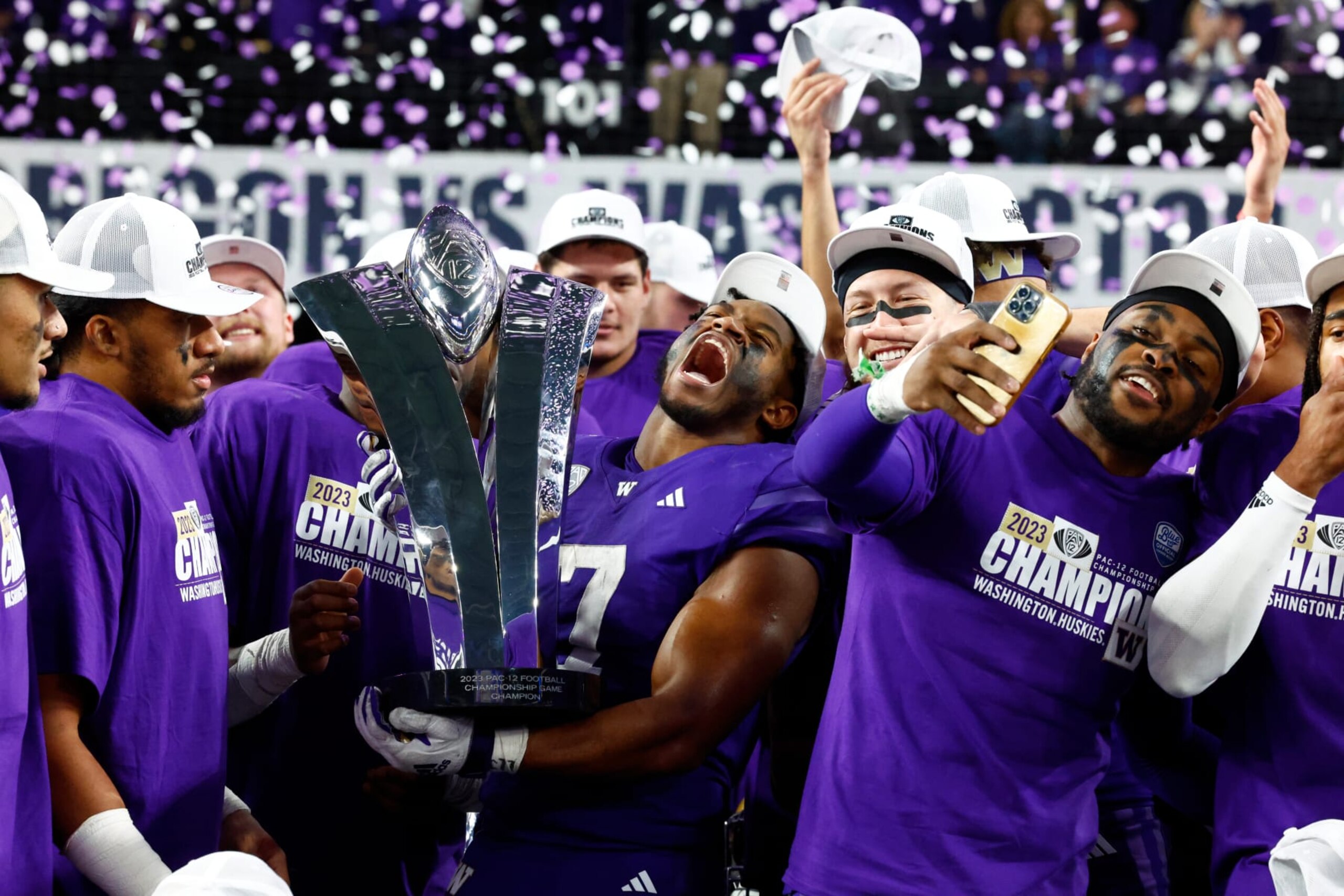LAS VEGAS, NV - DECEMBER 01: Washington Huskies running back Dillon Johnson (7) holds the championship trophy and celebrates with teammates after winning the Pac-12 Championship Game presented by 76 between the Oregon Ducks and the Washington Huskies on December 1, 2023 at Allegiant Stadium in Las Vegas, Nevada. (Photo by Jeff Speer/Icon Sportswire via Getty Images)