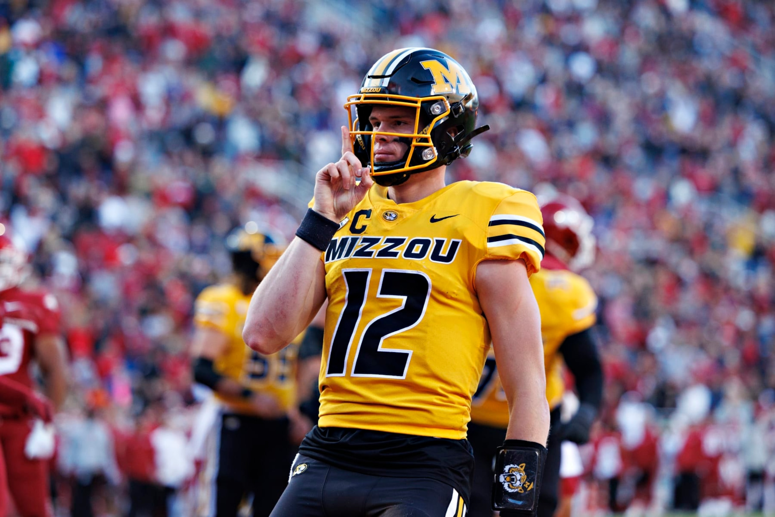 FAYETTEVILLE, ARKANSAS - NOVEMBER 24: Brady Cook #12 of the Missouri Tigers signals to the crowd after running the ball in for a touchdown in the first half of the game against the Arkansas Razorbacks at Donald W. Reynolds Razorback Stadium on November 24, 2023 in Fayetteville, Arkansas. (Photo by Wesley Hitt/Getty Images)
