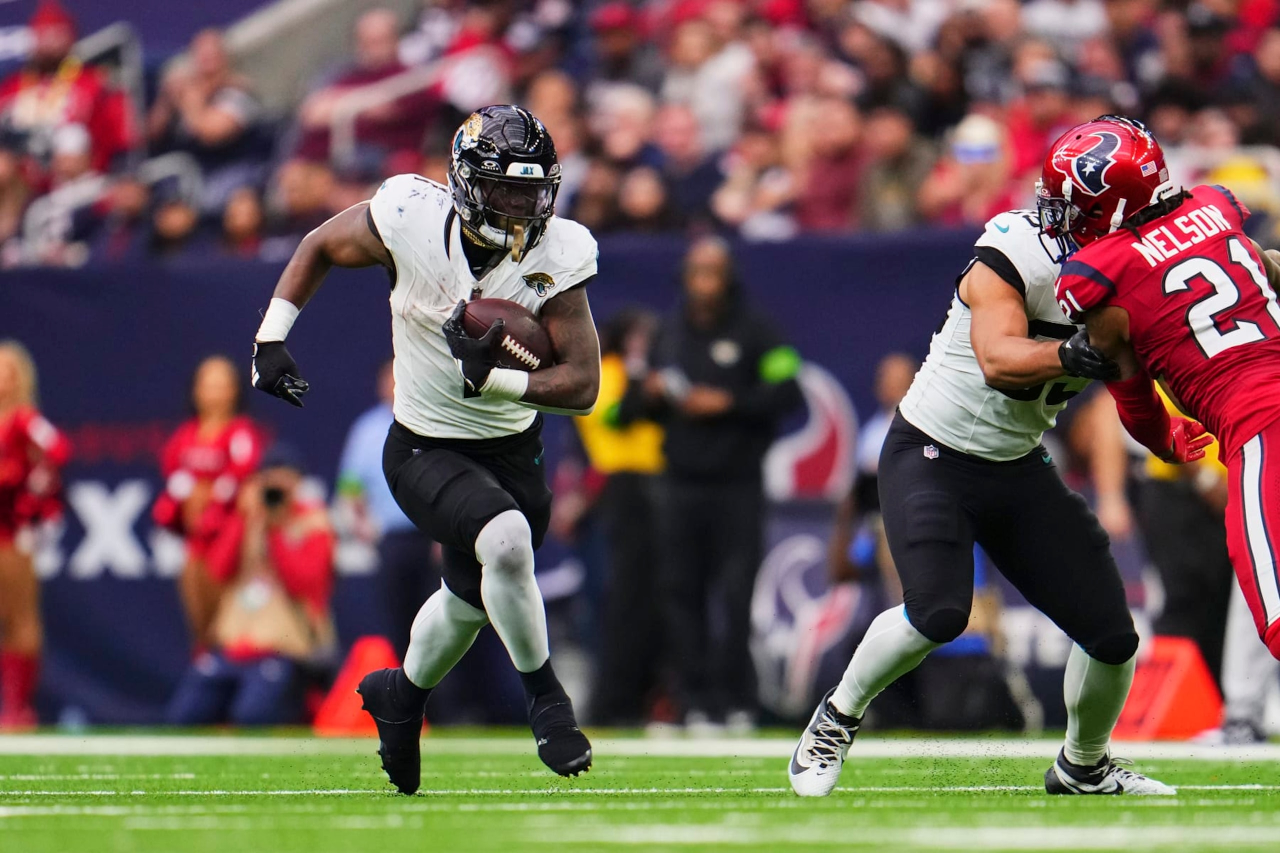 HOUSTON, TX - NOVEMBER 26: Travis Etienne Jr. #1 of the Jacksonville Jaguars carries the ball against the Houston Texans during the second half at NRG Stadium on November 26, 2023 in Houston, Texas. (Photo by Cooper Neill/Getty Images)