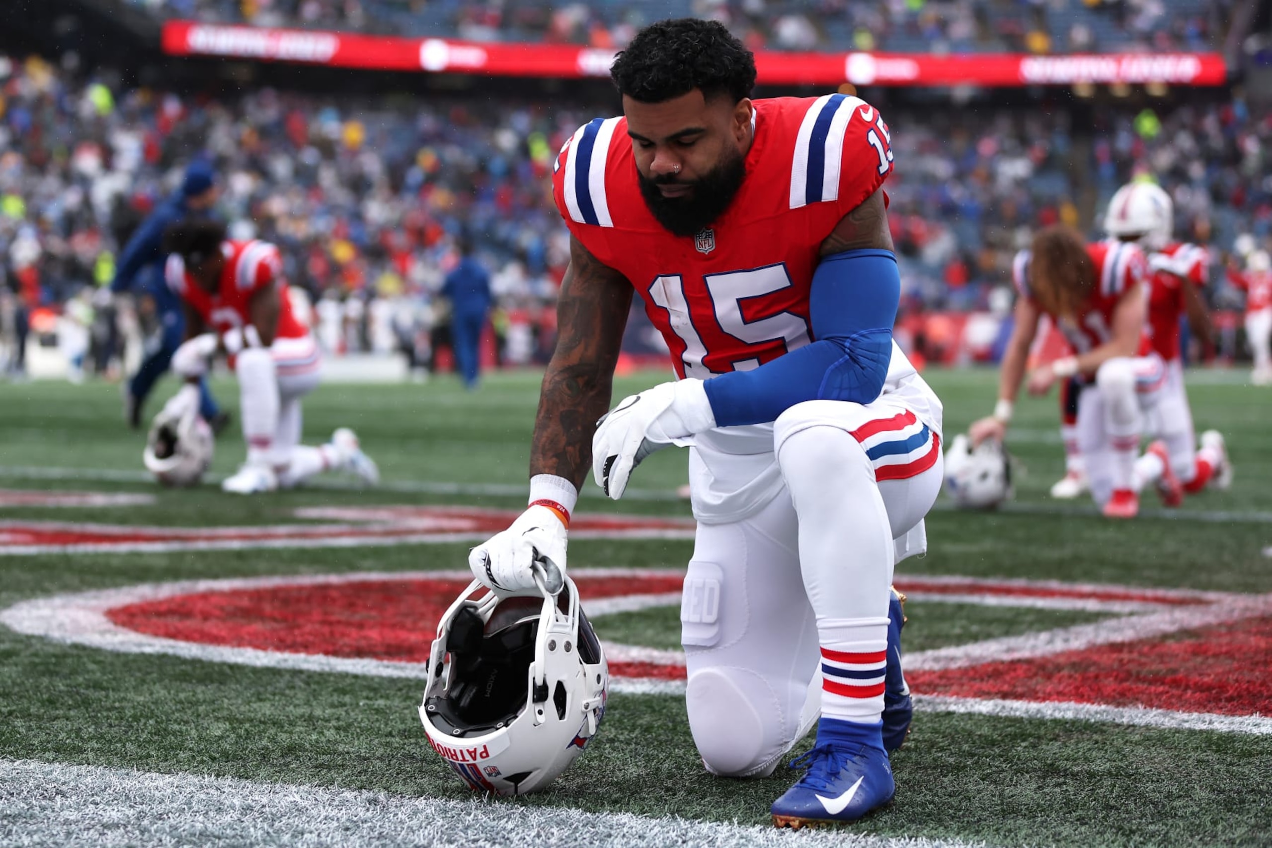 FOXBOROUGH, MASSACHUSETTS - DECEMBER 03: Ezekiel Elliott #15 of the New England Patriots kneels before the game against the Los Angeles Chargers at Gillette Stadium on December 03, 2023 in Foxborough, Massachusetts. (Photo by Maddie Meyer/Getty Images) FOXBOROUGH, MASSACHUSETTS - DECEMBER 03: Ezekiel Elliott #15 of the New England Patriots kneels before the game against the Los Angeles Chargers at Gillette Stadium on December 03, 2023 in Foxborough, Massachusetts. (Photo by Maddie Meyer/Getty Images)