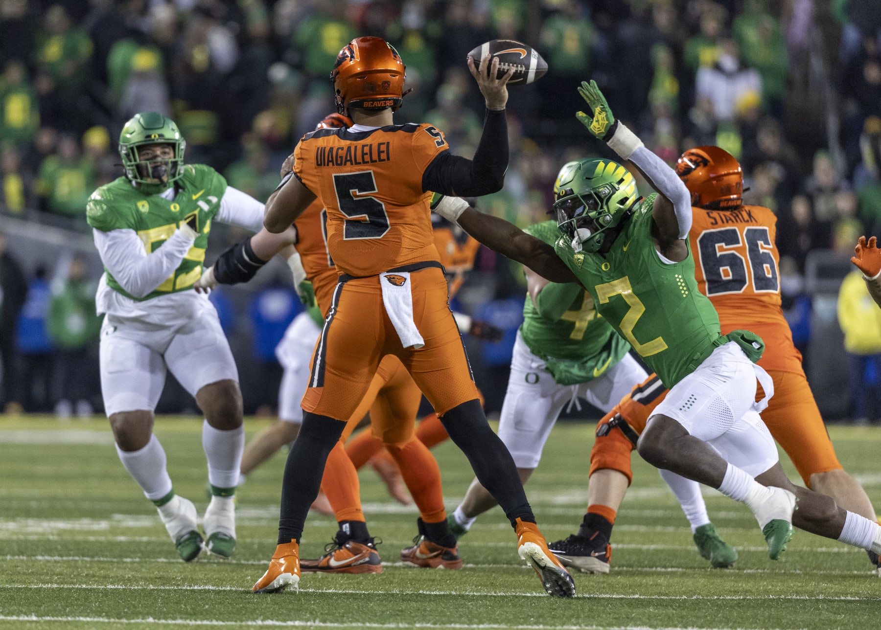 EUGENE, OREGON - NOVEMBER 24: Quarterback DJ Uiagalelei #5 of the Oregon State Beavers rolls out to pass as he is pressured by linebacker Jeffrey Bassa #2 of the Oregon Ducks during the second half at Autzen Stadium on November 24, 2023 in Eugene, Oregon. (Photo by Tom Hauck/Getty Images)