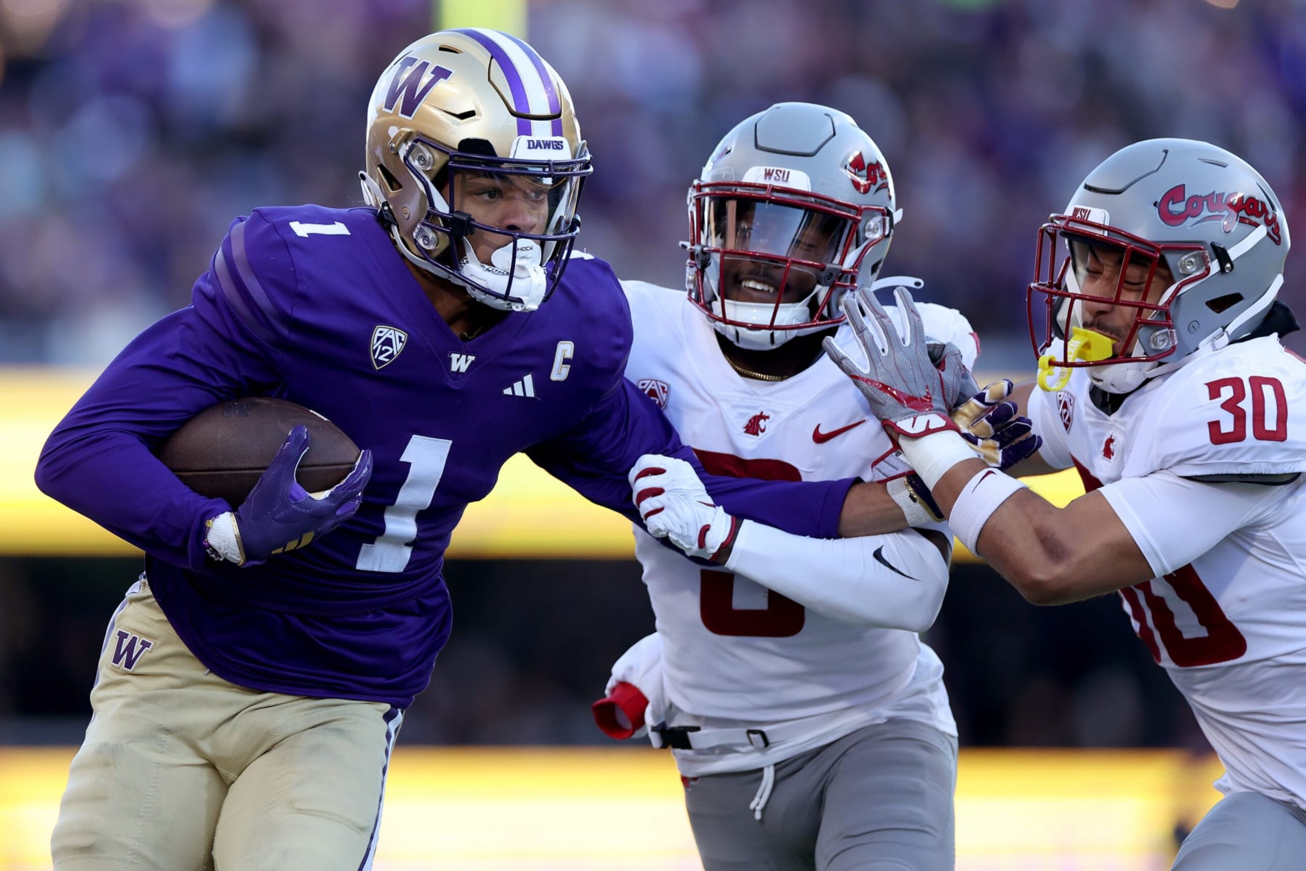 SEATTLE, WASHINGTON - NOVEMBER 25: Rome Odunze #1 of the Washington Huskies catches the ball against Cam Lampkin #3 of the Washington State Cougars and Jackson Lataimua #30 of the Washington State Cougars during the first quarter at Husky Stadium on November 25, 2023 in Seattle, Washington. (Photo by Steph Chambers/Getty Images)