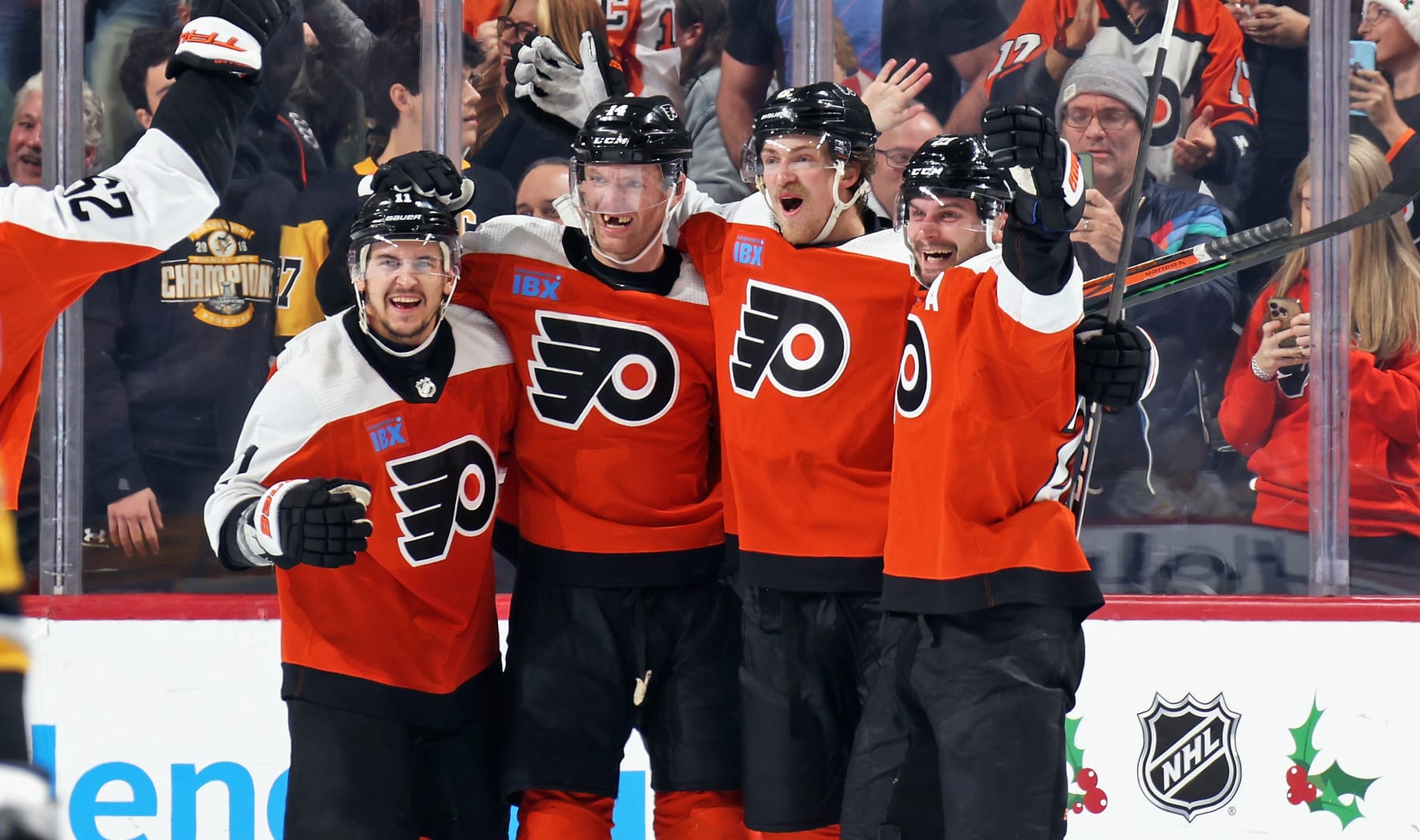 PHILADELPHIA, PENNSYLVANIA - DECEMBER 04: Sean Couturier #14 of the Philadelphia Flyers celebrates his game-winning goal in overtime against the Pittsburgh Penguins with Travis Konecny #11, Travis Sanheim #6, and Scott Laughton #21 at the Wells Fargo Center on December 4, 2023 in Philadelphia, Pennsylvania. The Flyers went on to defeat the Penguins in overtime 2-1. (Photo by Len Redkoles/NHLI via Getty Images)