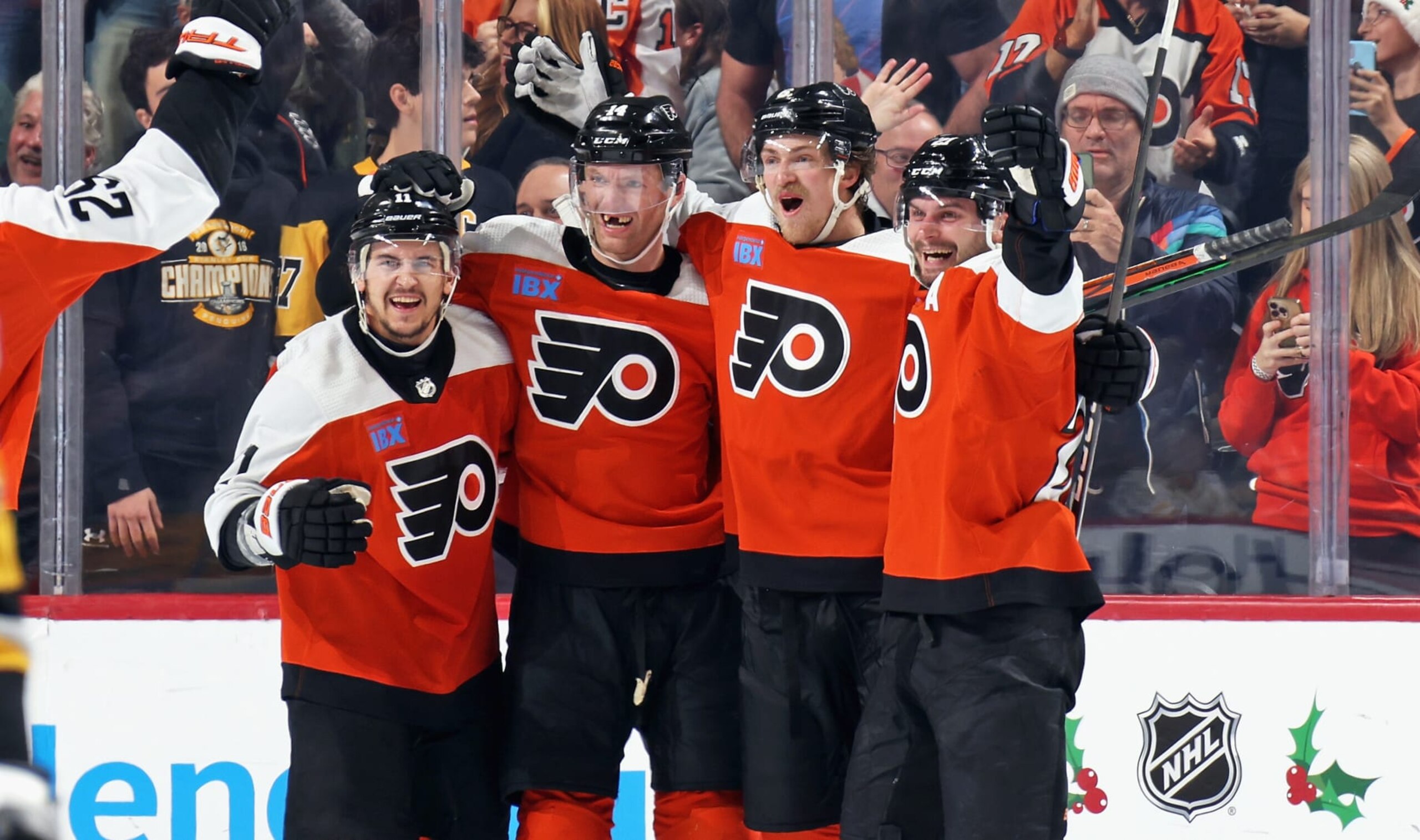 PHILADELPHIA, PENNSYLVANIA - DECEMBER 04: Sean Couturier #14 of the Philadelphia Flyers celebrates his game-winning goal in overtime against the Pittsburgh Penguins with Travis Konecny #11, Travis Sanheim #6, and Scott Laughton #21 at the Wells Fargo Center on December 4, 2023 in Philadelphia, Pennsylvania. The Flyers went on to defeat the Penguins in overtime 2-1. (Photo by Len Redkoles/NHLI via Getty Images)